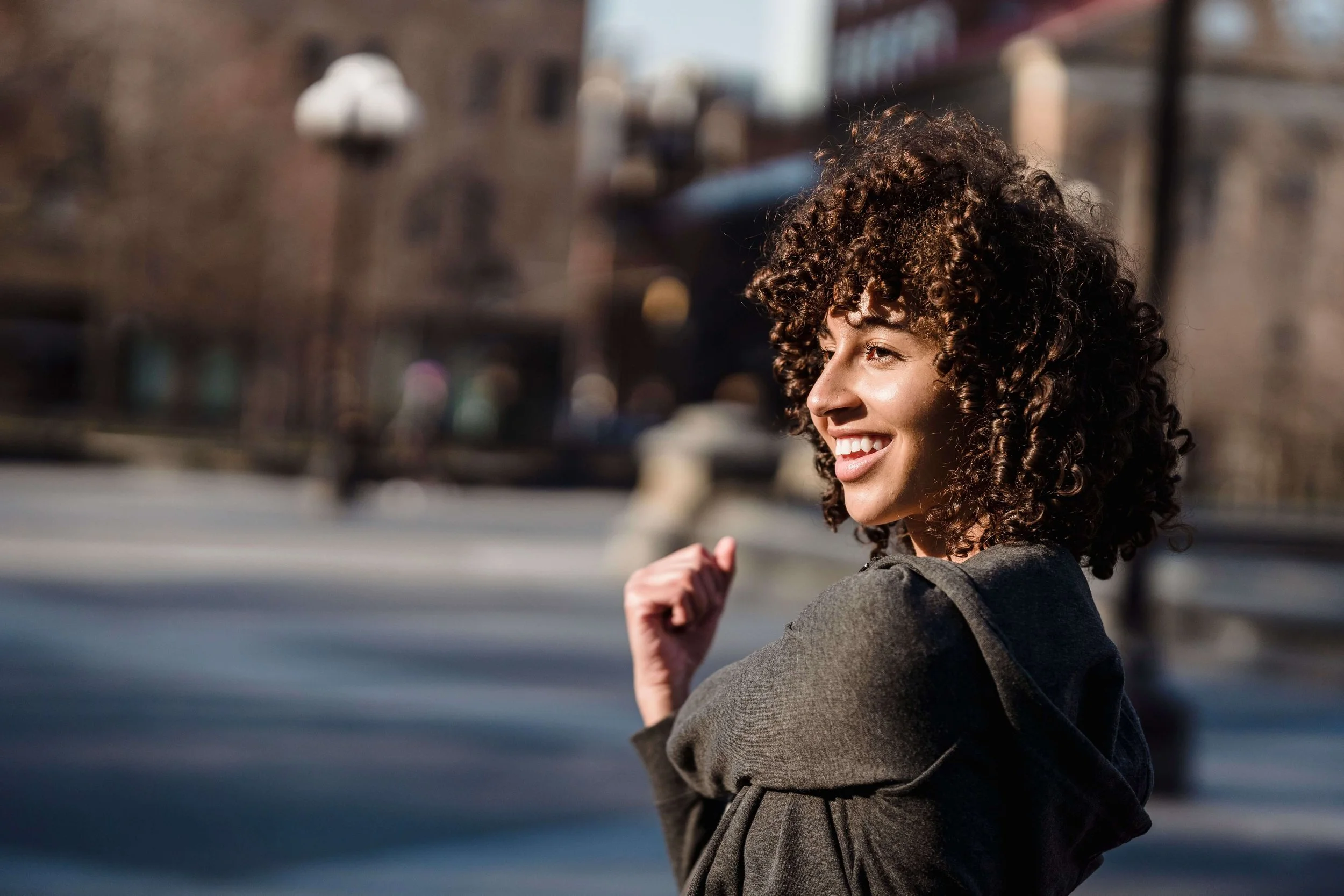 Woman smiling outdoors, representing greater ease, self-compassion, and fulfillment supported through therapy for perfectionist women in Bay Shore, NY.