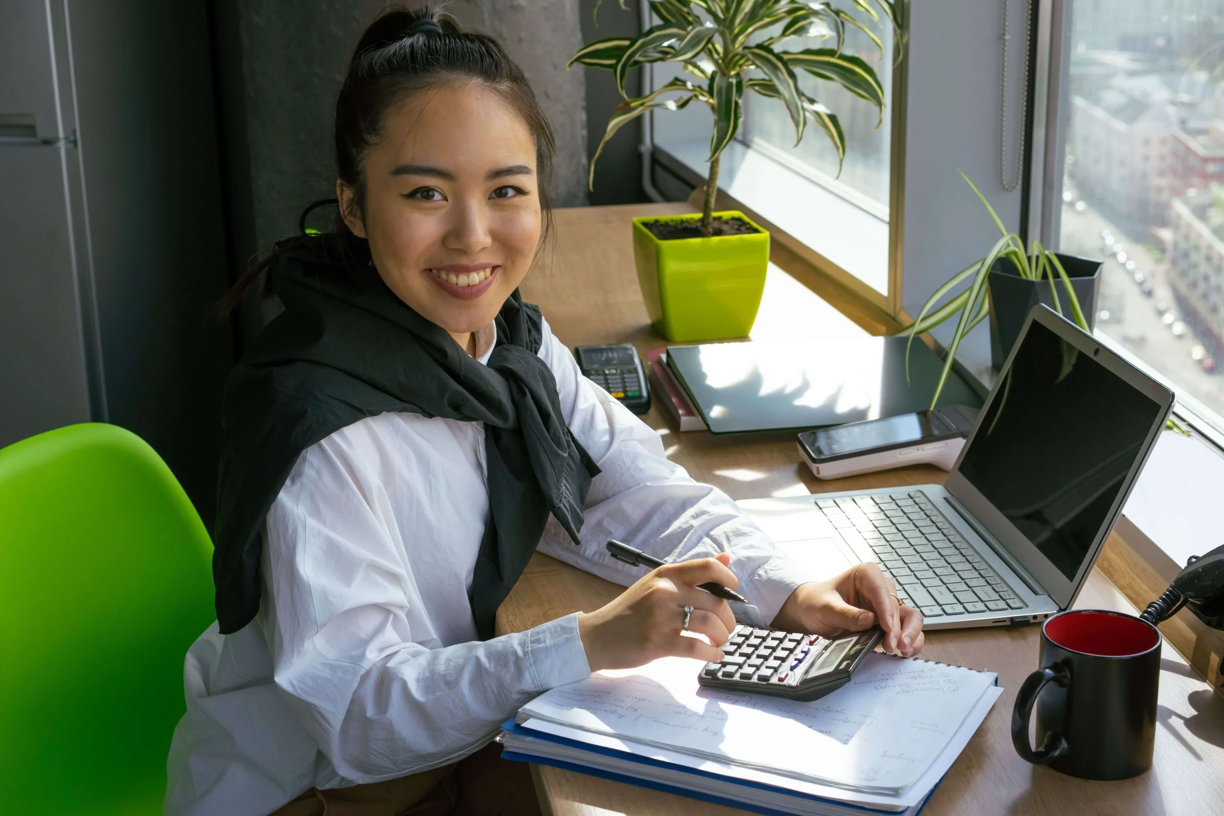 Woman smiling while at work, representing improved well-being, resilience, and healthier work-life balance through therapy for burnout in Bay Shore, NY.