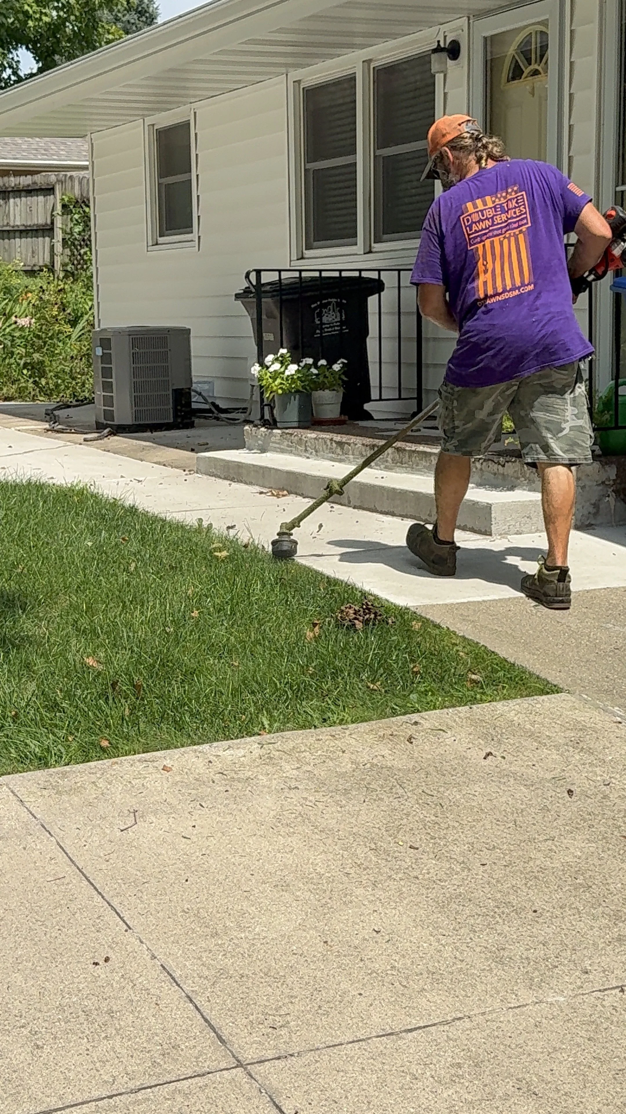 String trimming lawn in Altoona, IA