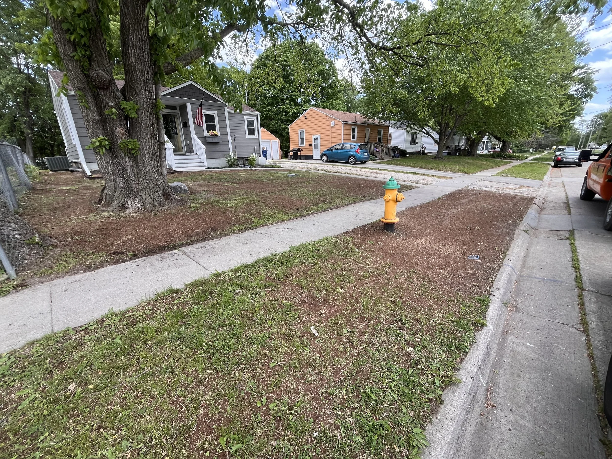 Bare, thin grass of a lawn in Altoona, IA before Double Take Lawn Services lawn renovation service.