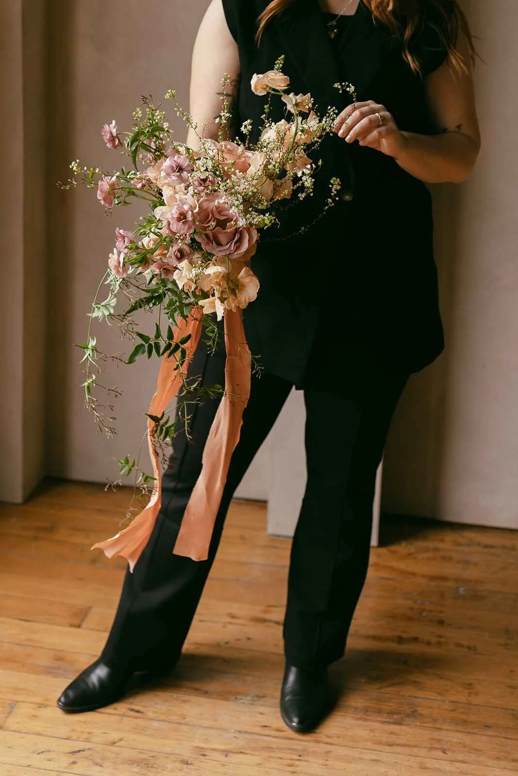 Founder of Moonflower Design Co holding spring bouquet and playing with it.