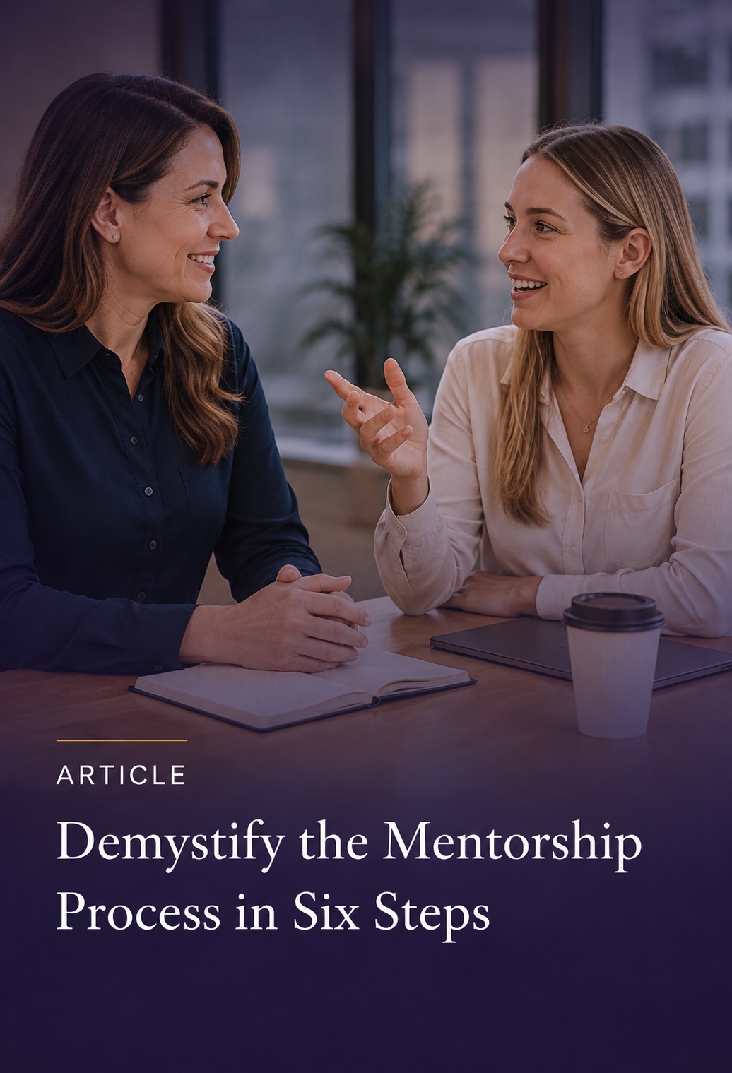 Two women having a conversation in an office with a notebook and coffee cup on the table.