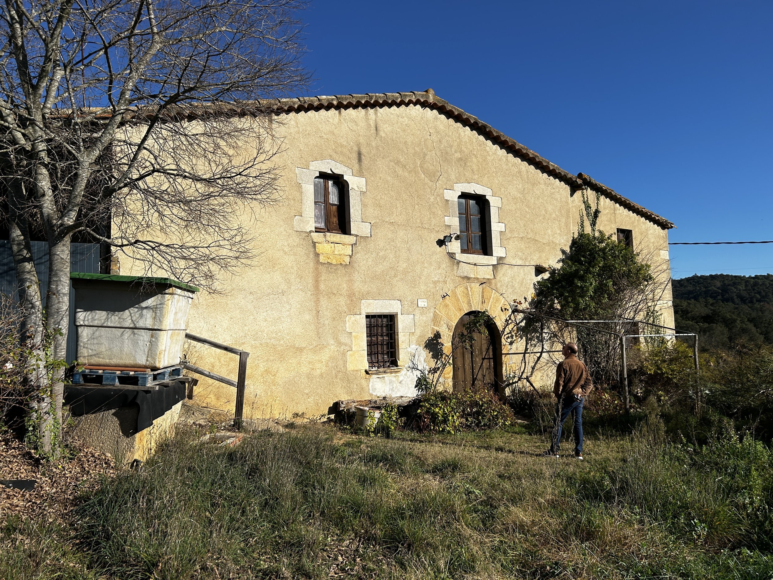 Masia+for+sale+at+Amazing+Girones+Expansive+brick-paved+outdoor+area+with+bare+tree+under+dramatic+sky+hinting+at+rural+landscape.jpeg