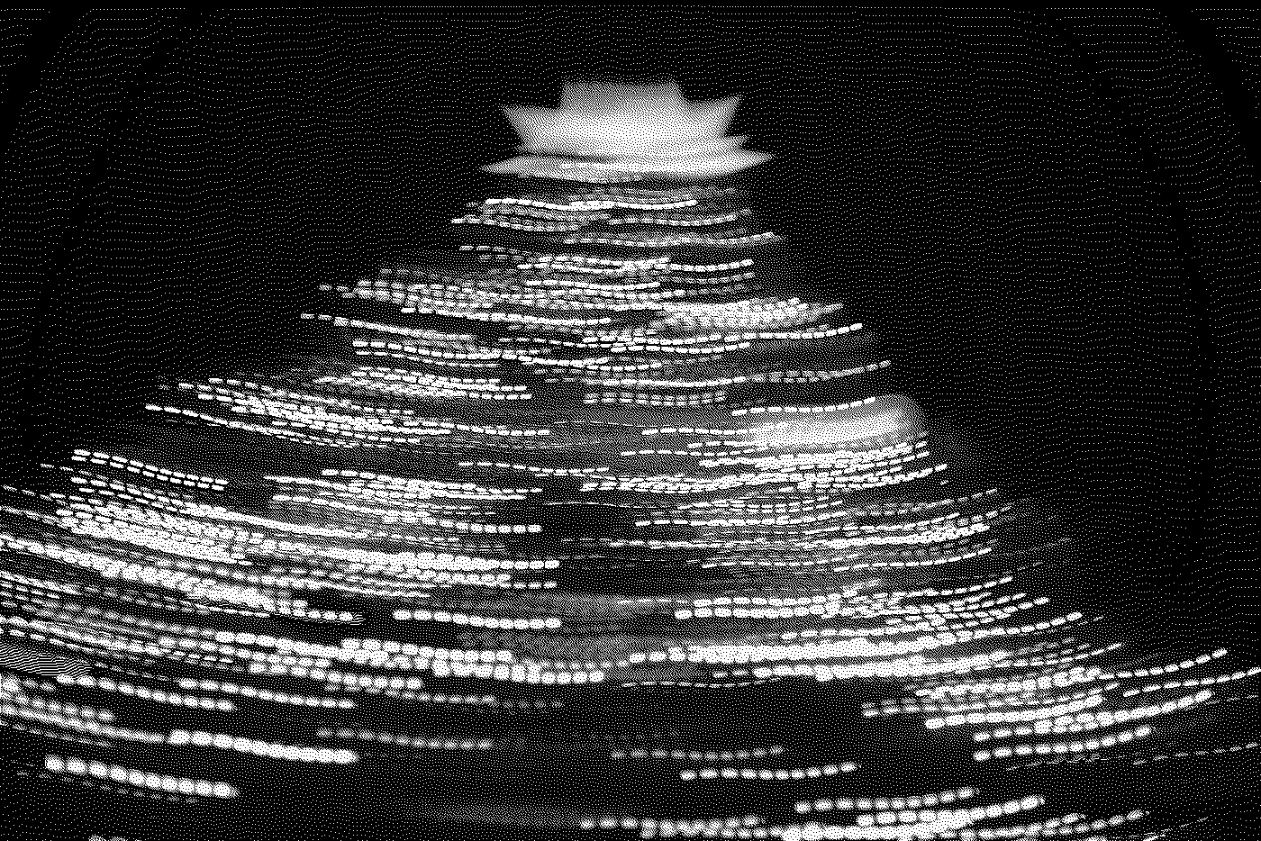 Black and white photograph of a multi-tiered pagoda with a detailed roof structure, illuminated at night.