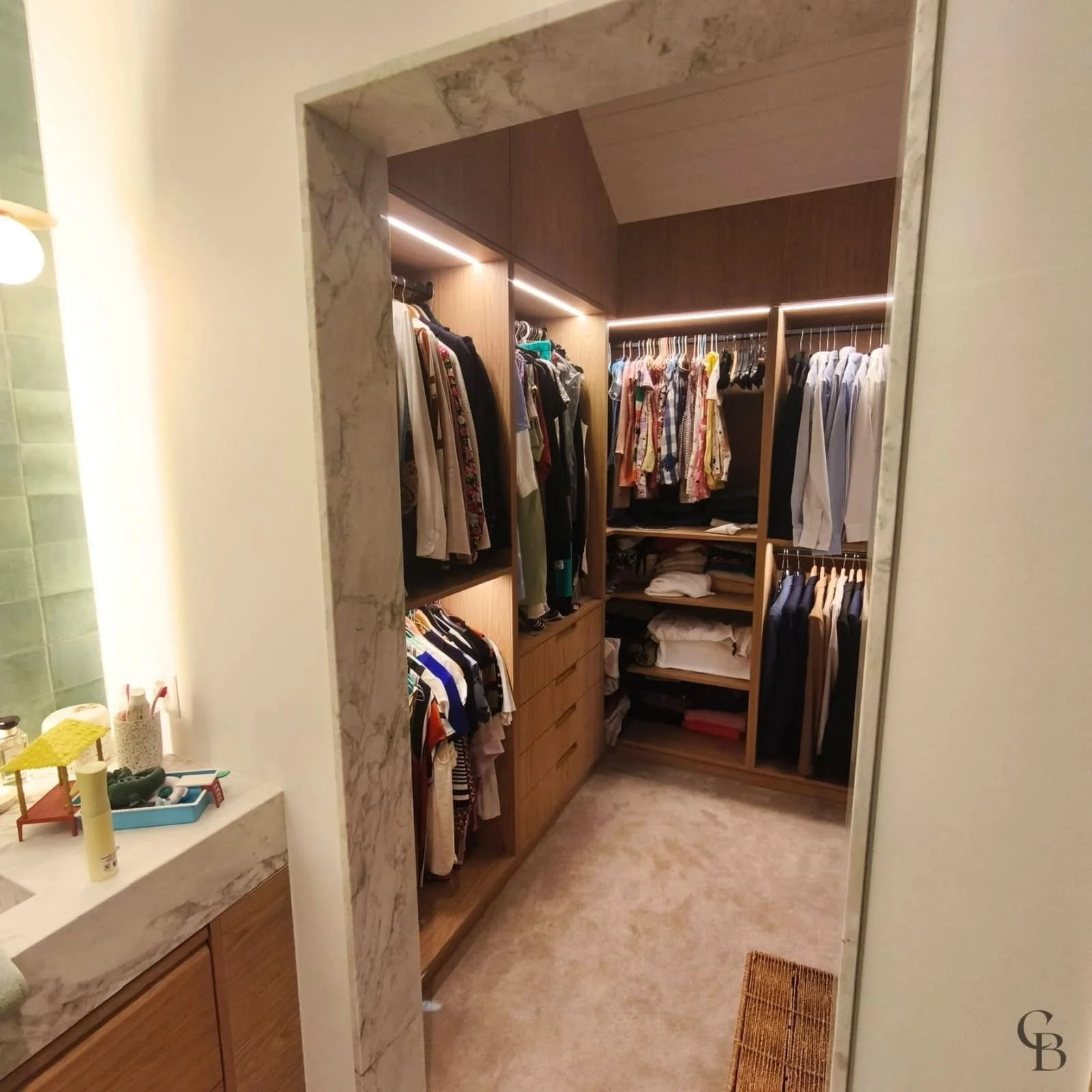 Depuis la salle de bains parentale, Concept & Bois dévoile un dressing sur mesure en bois où habillage mural, penderies ouvertes et éclairage LED intégré créent un espace élégant, chaleureux et parfaitement organisé.