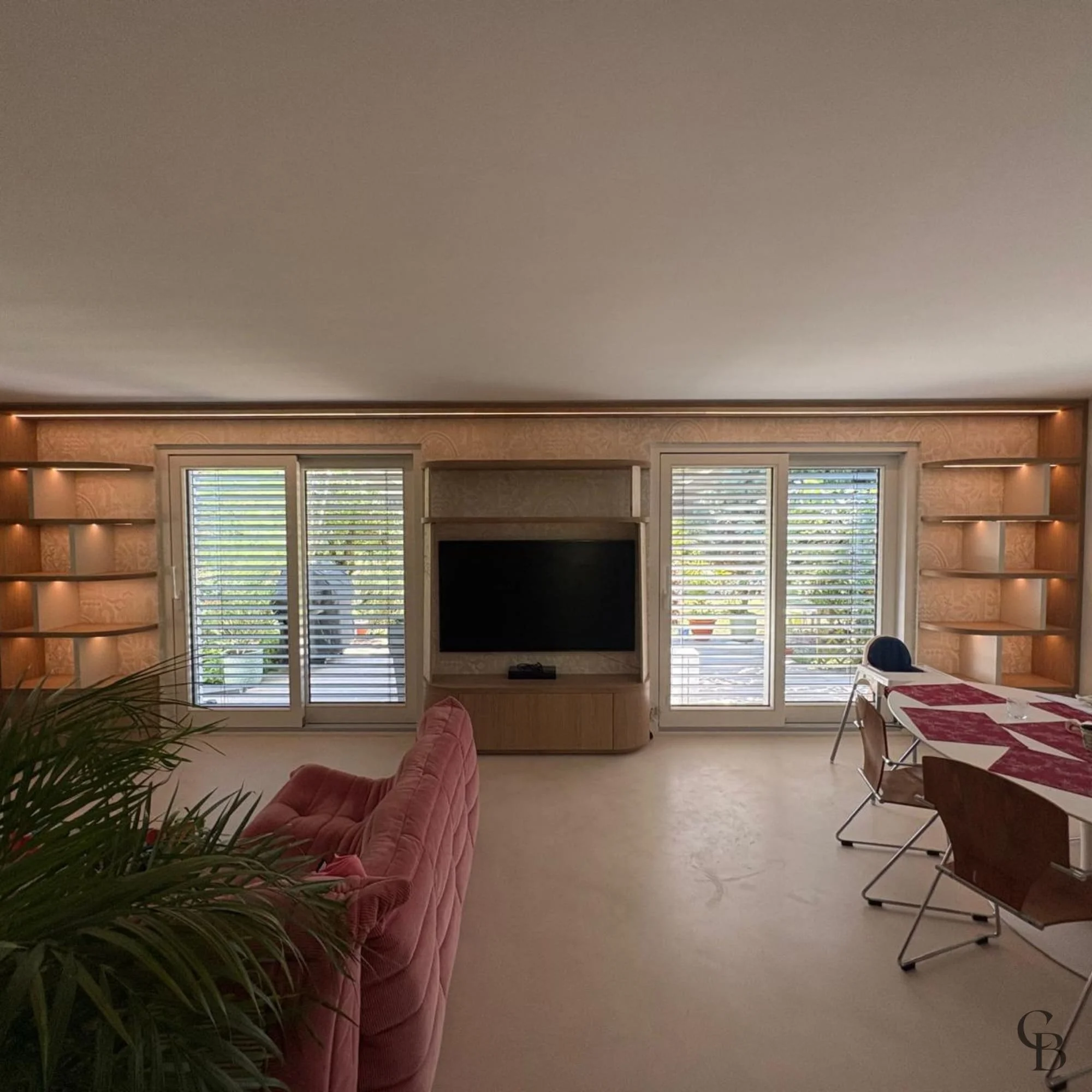 Vue d'ensemble du nouvel agencement intérieur avec bibliothèque sur mesure, meuble TV intégré et éclairage LED.