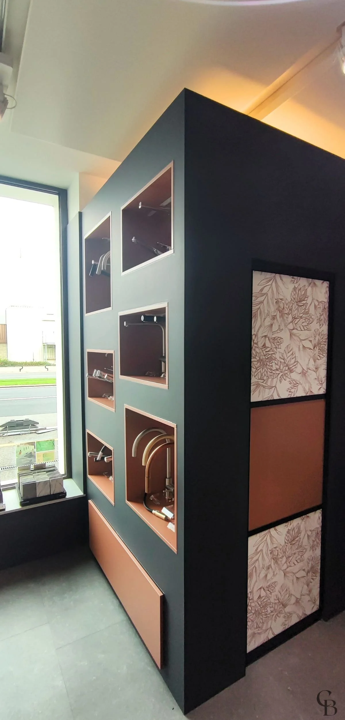 Concept & Bois a conçu et fabriqué cette cloison sur mesure en MDF peint anthracite, intégrant des niches de présentation dédiées à la robinetterie. Cet agencement permet aux visiteurs du showroom de découvrir différentes finitions tout en optimisant