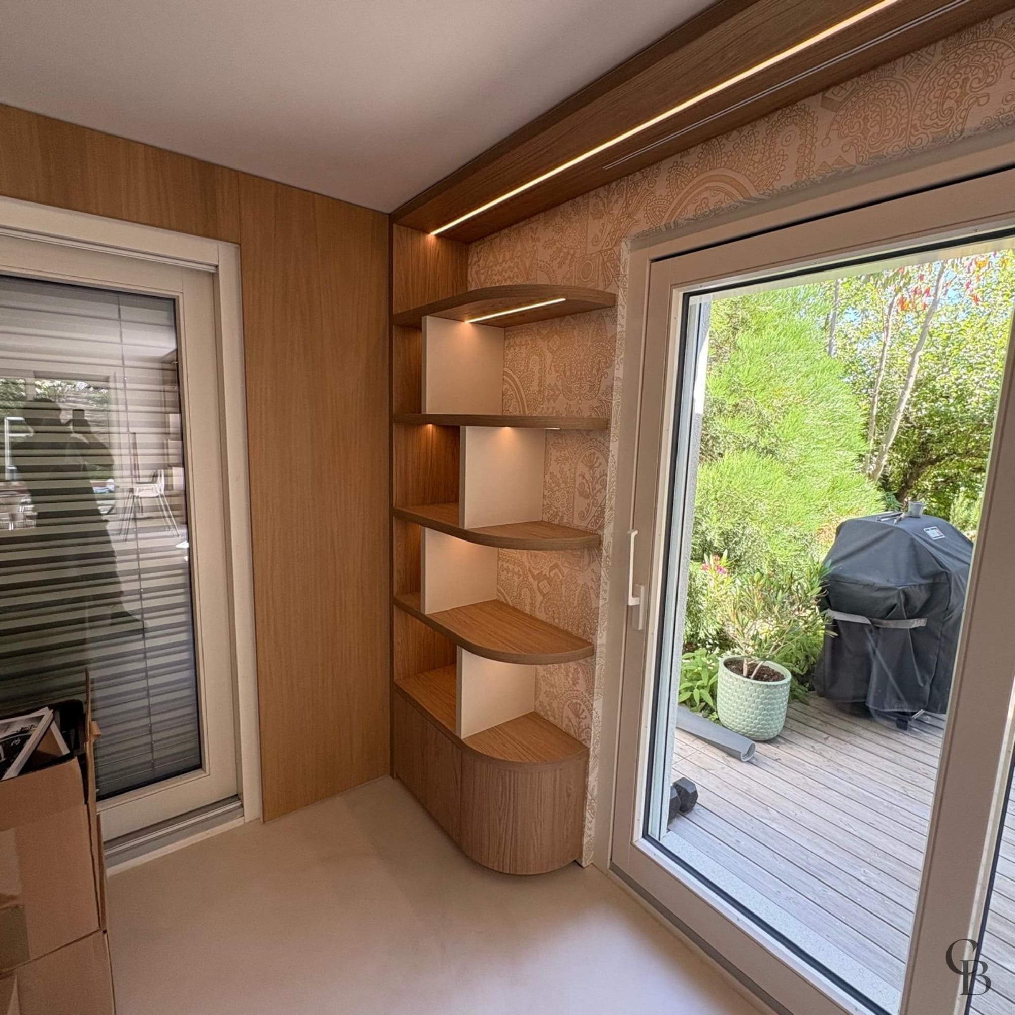 Détail des finitions d'une bibliothèque sur mesure avec étagères design et éclairage LED fabriquée par Concept & Bois à Genève.