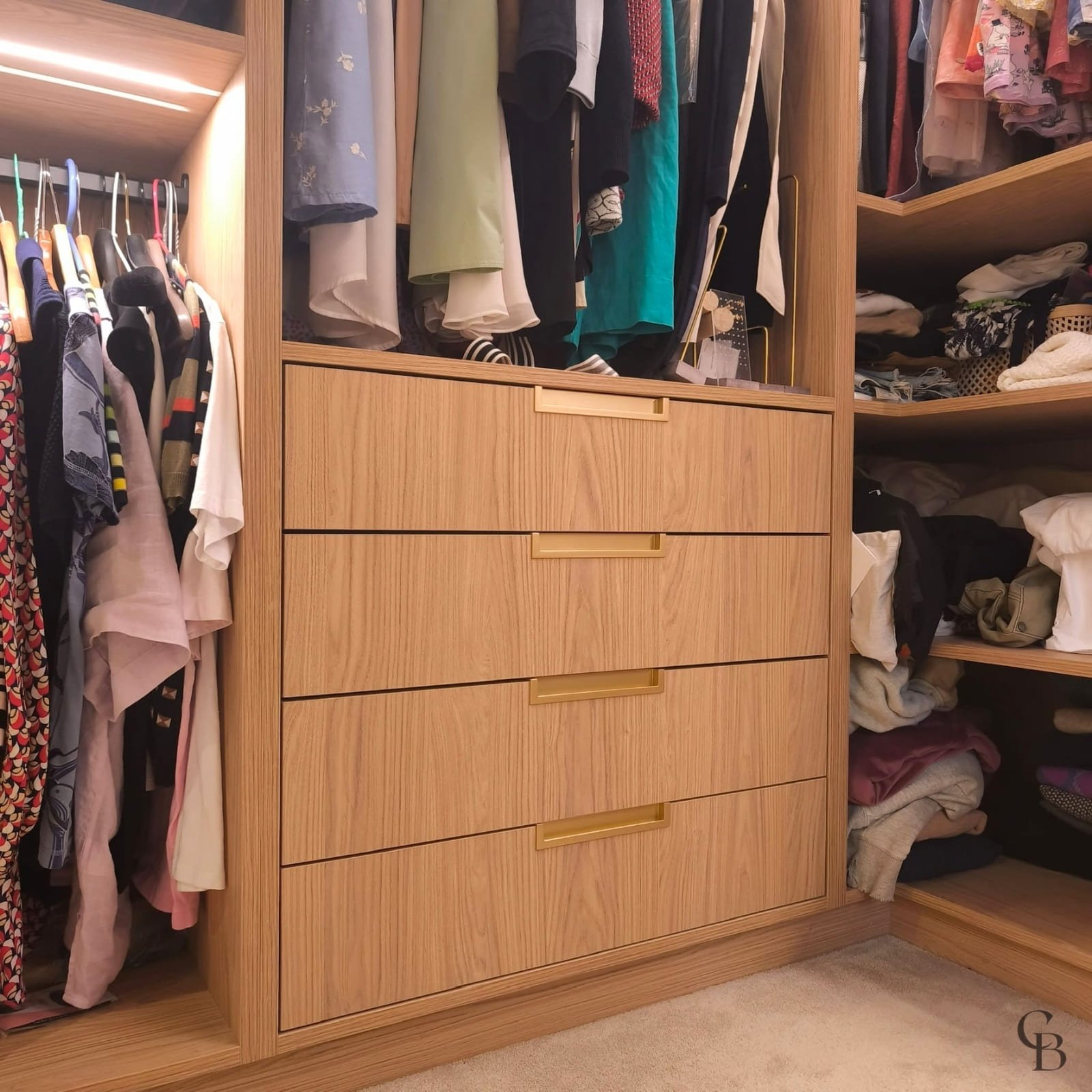 Détail des tiroirs d'un dressing sur mesure en bois avec continuité du veinage, réalisé par Concept & Bois dans une villa à Nyon.