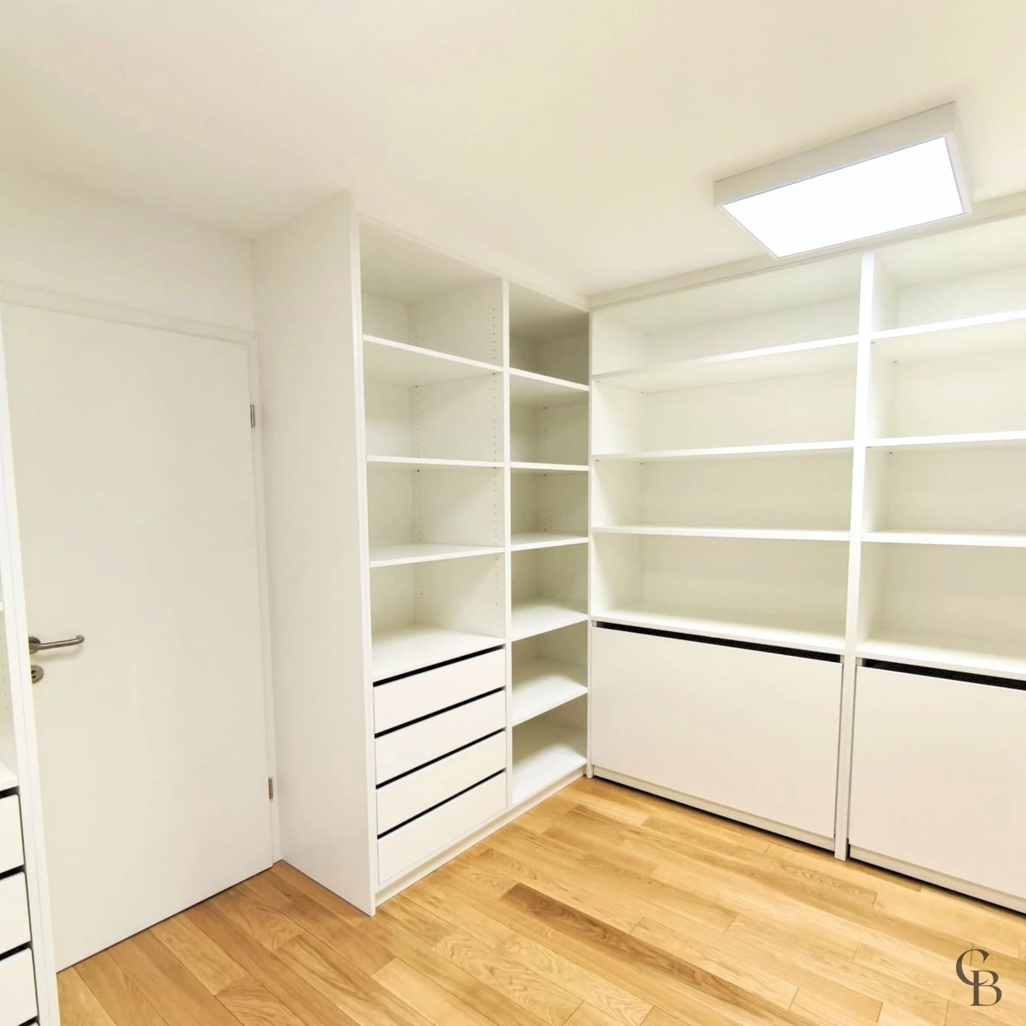 Dressing sur mesure réalisé à Genève avec étagères, tiroirs intégrés et espaces de rangement personnalisés.
