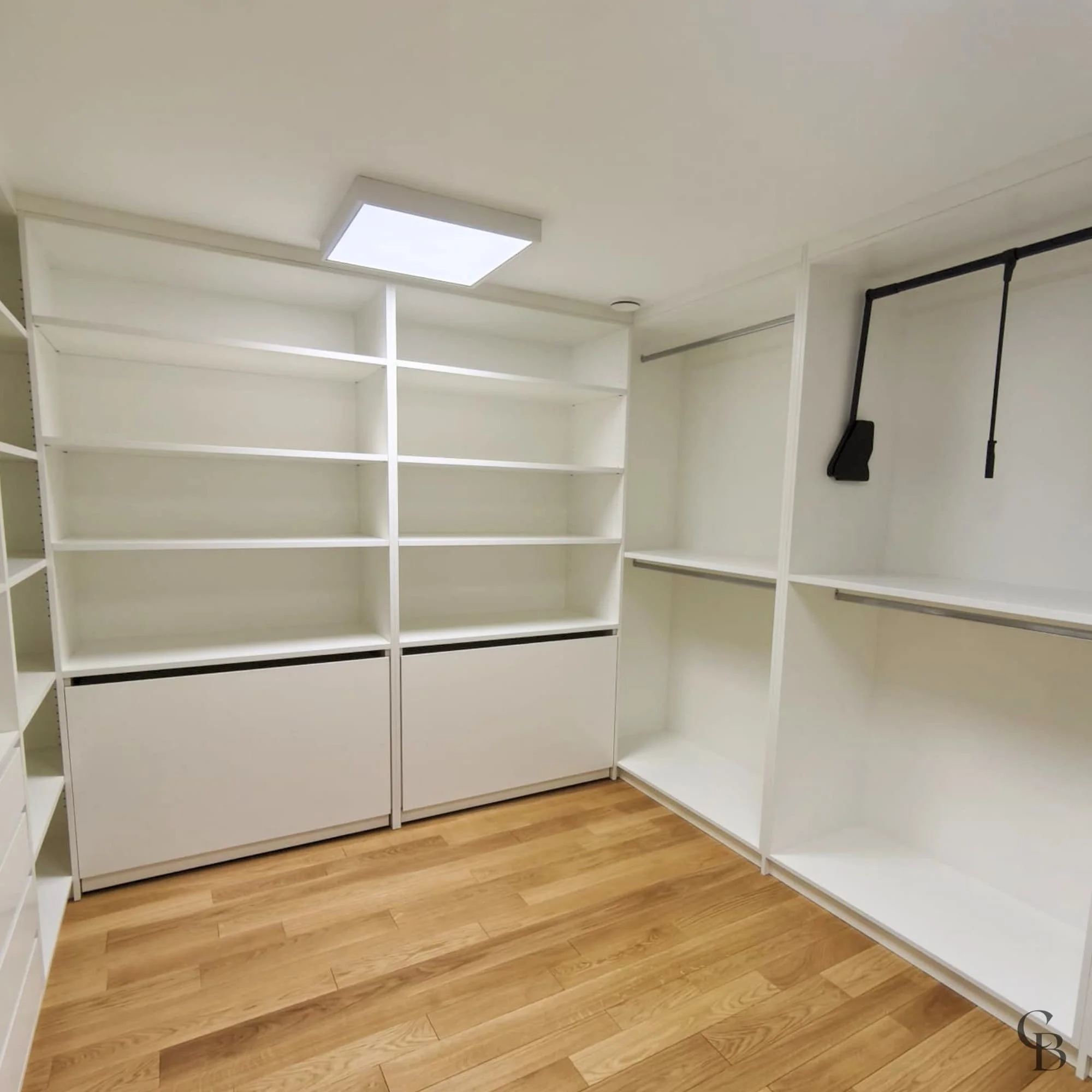Dressing sur mesure comprenant penderies, étagères et espaces de rangement adaptés aux besoins du client.