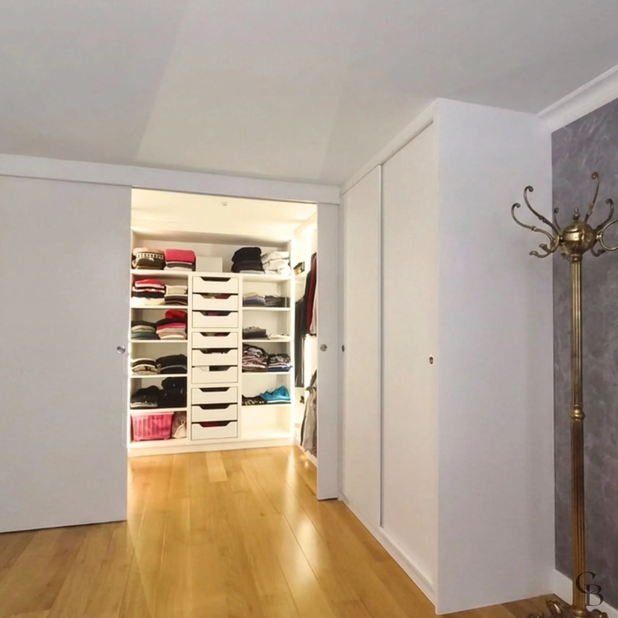 Vue d'ensemble du dressing fermé parfaitement intégré à la chambre.