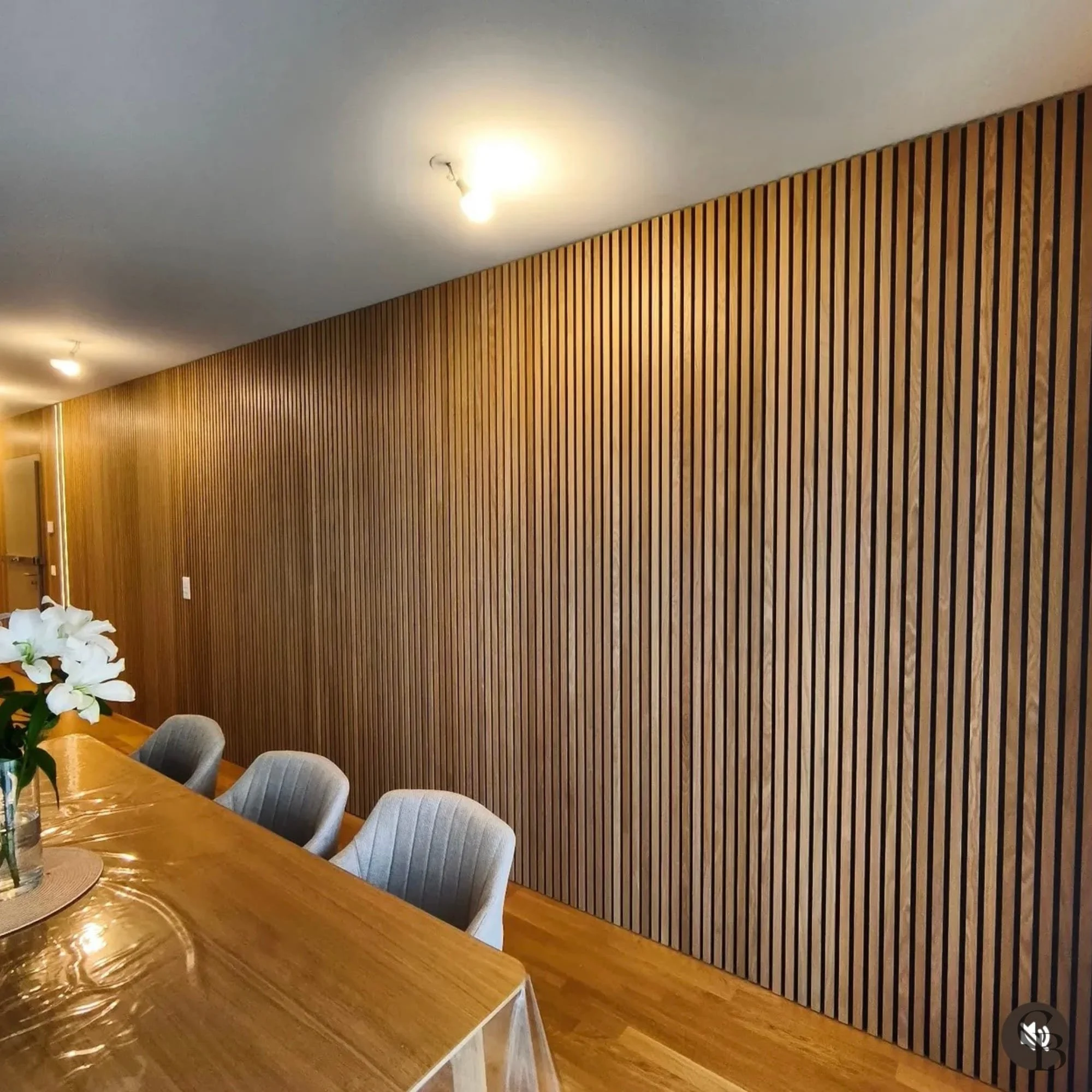 Agencement intérieur sur mesure réalisé à Genève avec un habillage mural en bois, des tasseaux décoratifs et une finition artisanale qui valorise les espaces de vie avec élégance et précision.