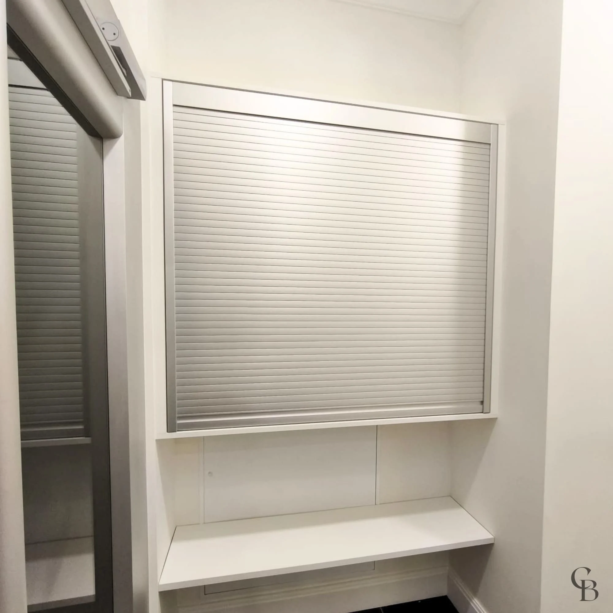 Meuble de rangement sur mesure avec volet roulant fermé réalisé dans le cadre d’un aménagement intérieur personnalisé.
