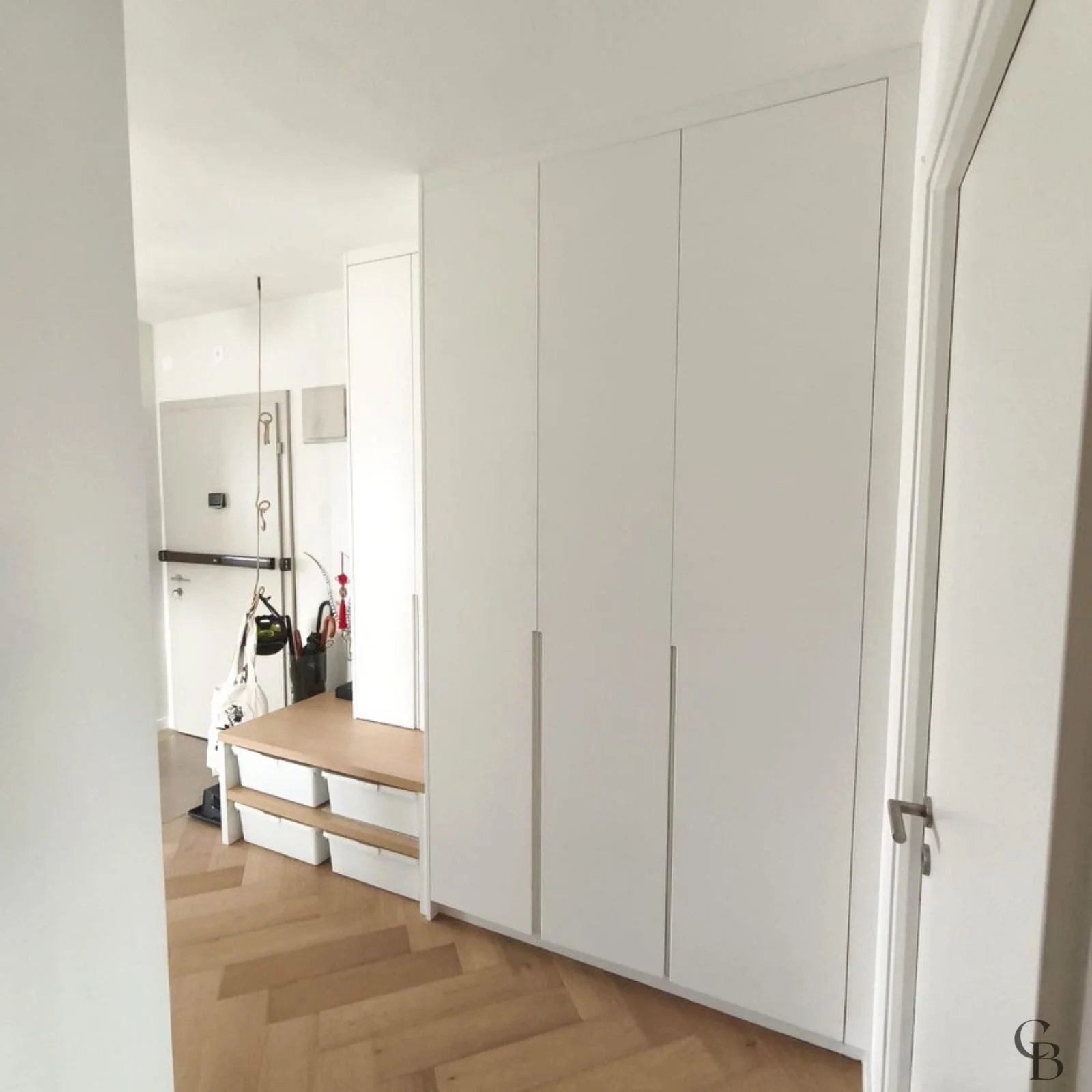 Aménagement d'entrée sur mesure avec armoire, banc et rangements intégrés réalisé par Concept & Bois à Genève