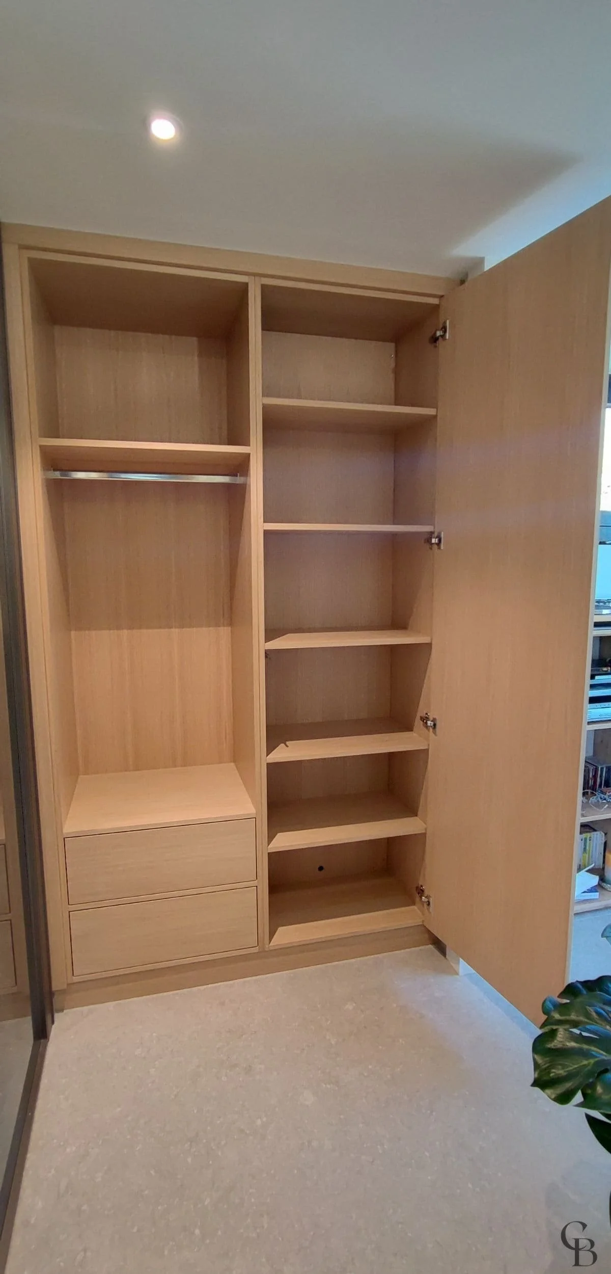 Aménagement intérieur de l'armoire avec tiroirs à ouverture push, penderie ouverte et fond démontable permettant l'accès aux installations techniques.