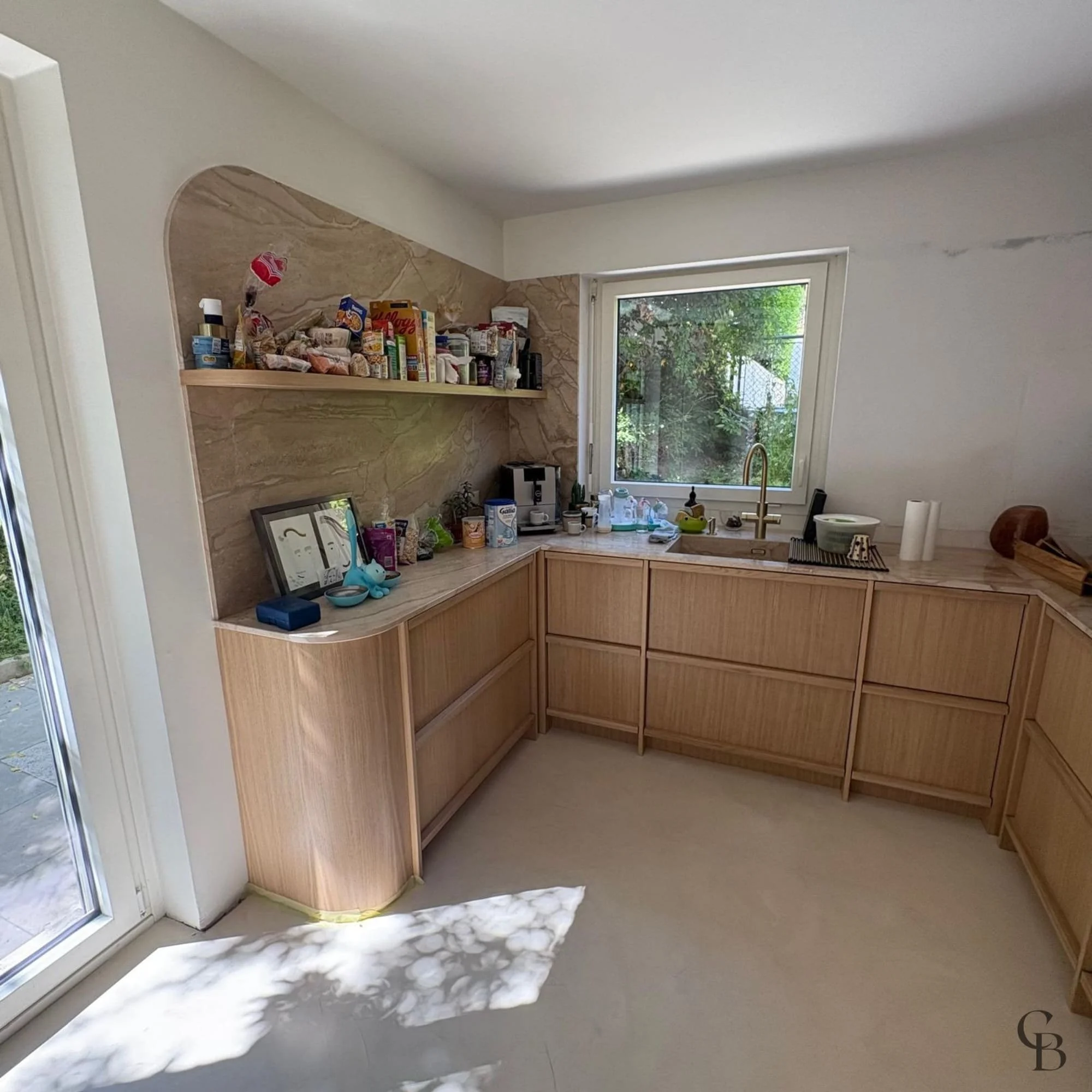 Cuisine en U conçue sur mesure pour optimiser l'espace avec des rangements fonctionnels et des matériaux haut de gamme.