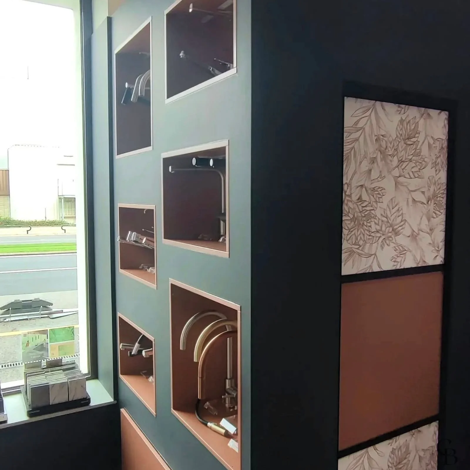 Vue d'ensemble de la cloison sur mesure réalisée par Concept & Bois pour ce showroom professionnel à Carouge. Conçue en MDF peint anthracite, elle intègre des niches d'exposition côté visiteurs ainsi qu'un espace de rangement fermé par une façade cou