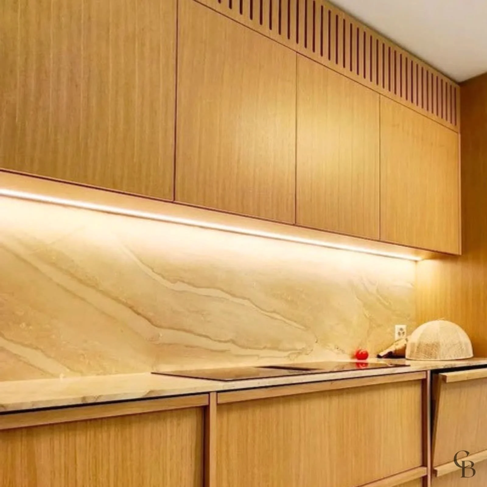 Plan de travail, crédence minérale et éclairage intégré dans une cuisine sur mesure réalisée à Nyon par Concept & Bois