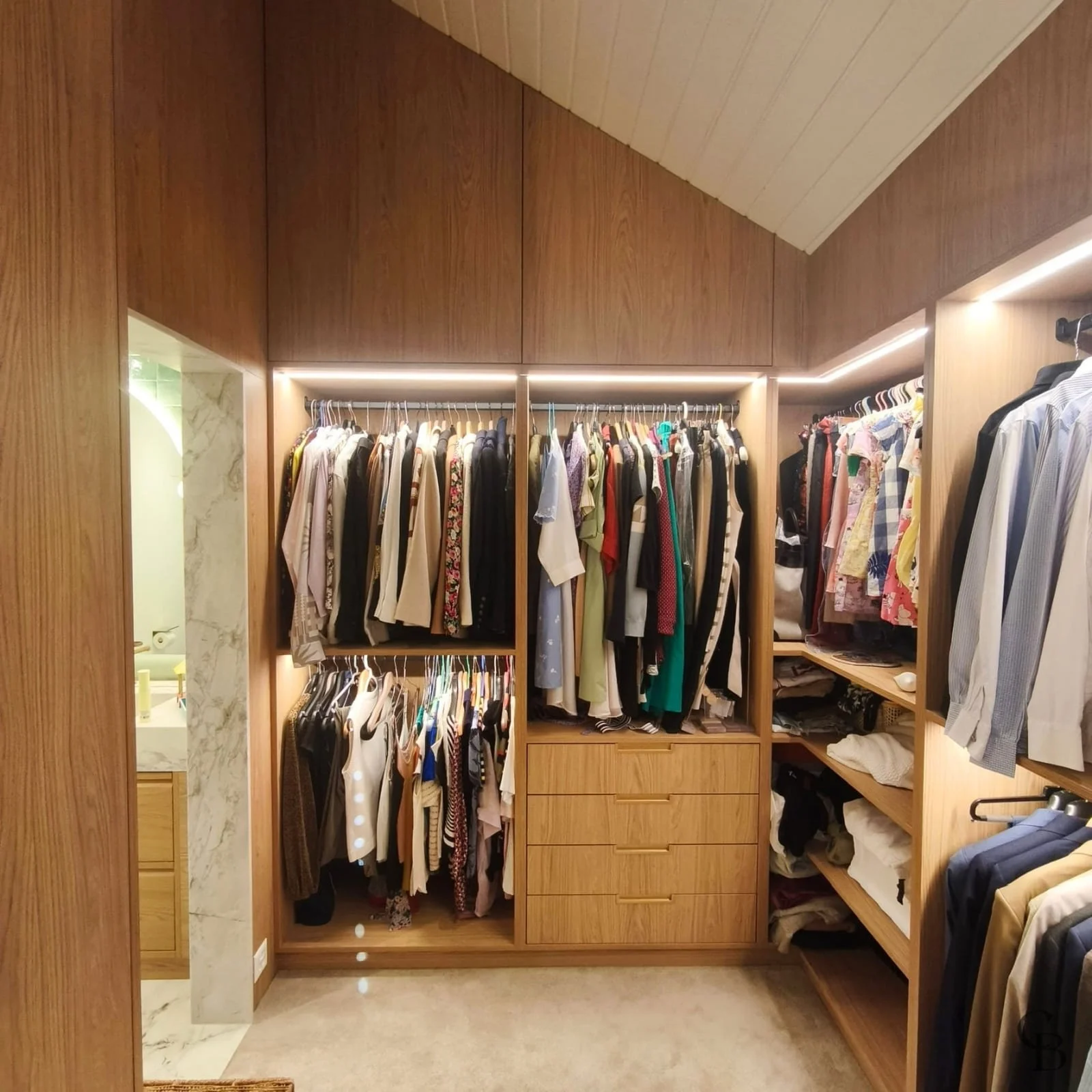 Dressing parental sur mesure en bois avec éclairage LED, mobilier intégré et rangements personnalisés, réalisé par Concept & Bois dans une villa à Nyon.