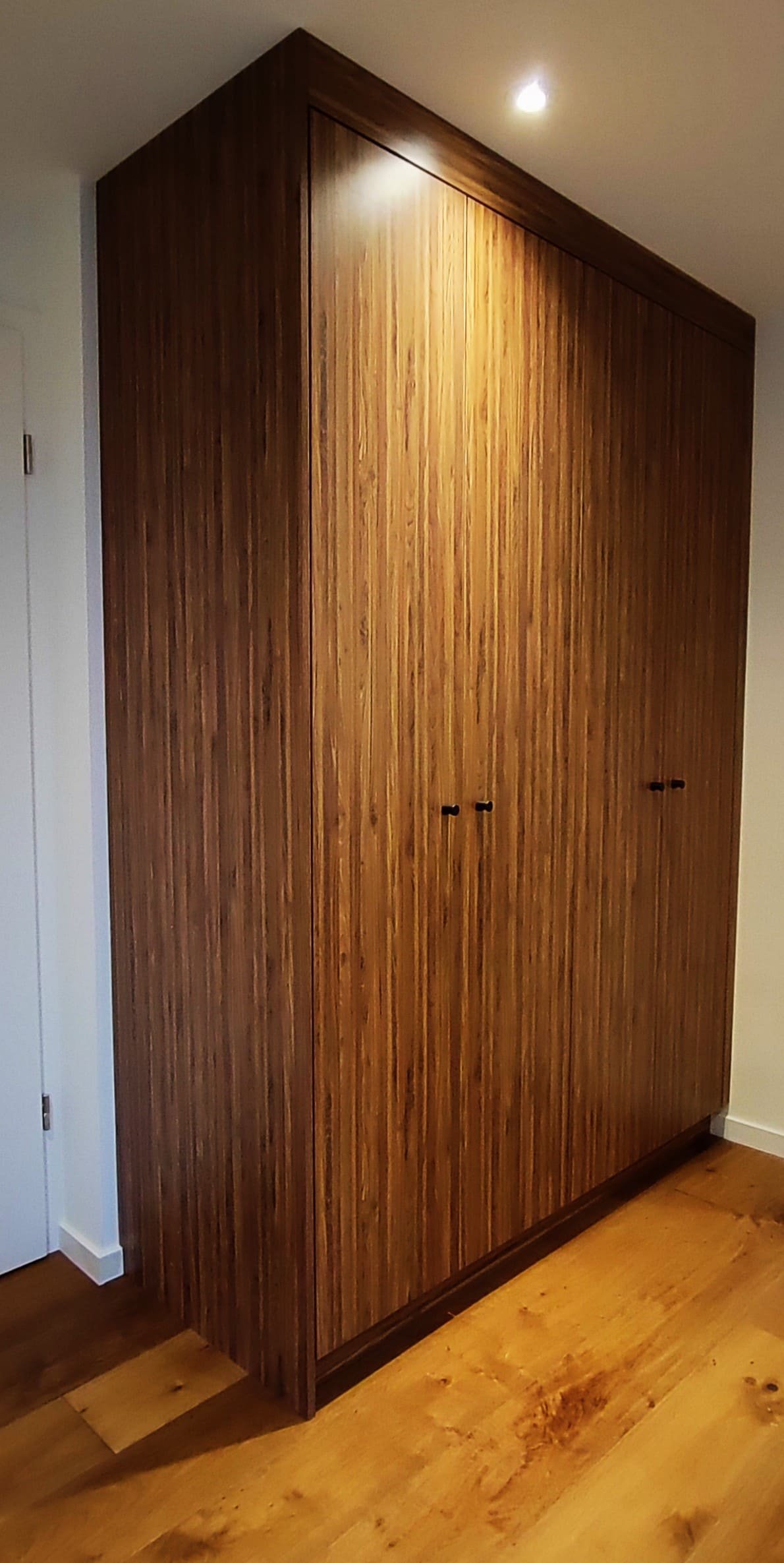 Armoire sur mesure en bois réalisée dans une villa à Veyrier, avec rangements intégrés, finitions haut de gamme et design parfaitement intégré à l'architecture intérieure.