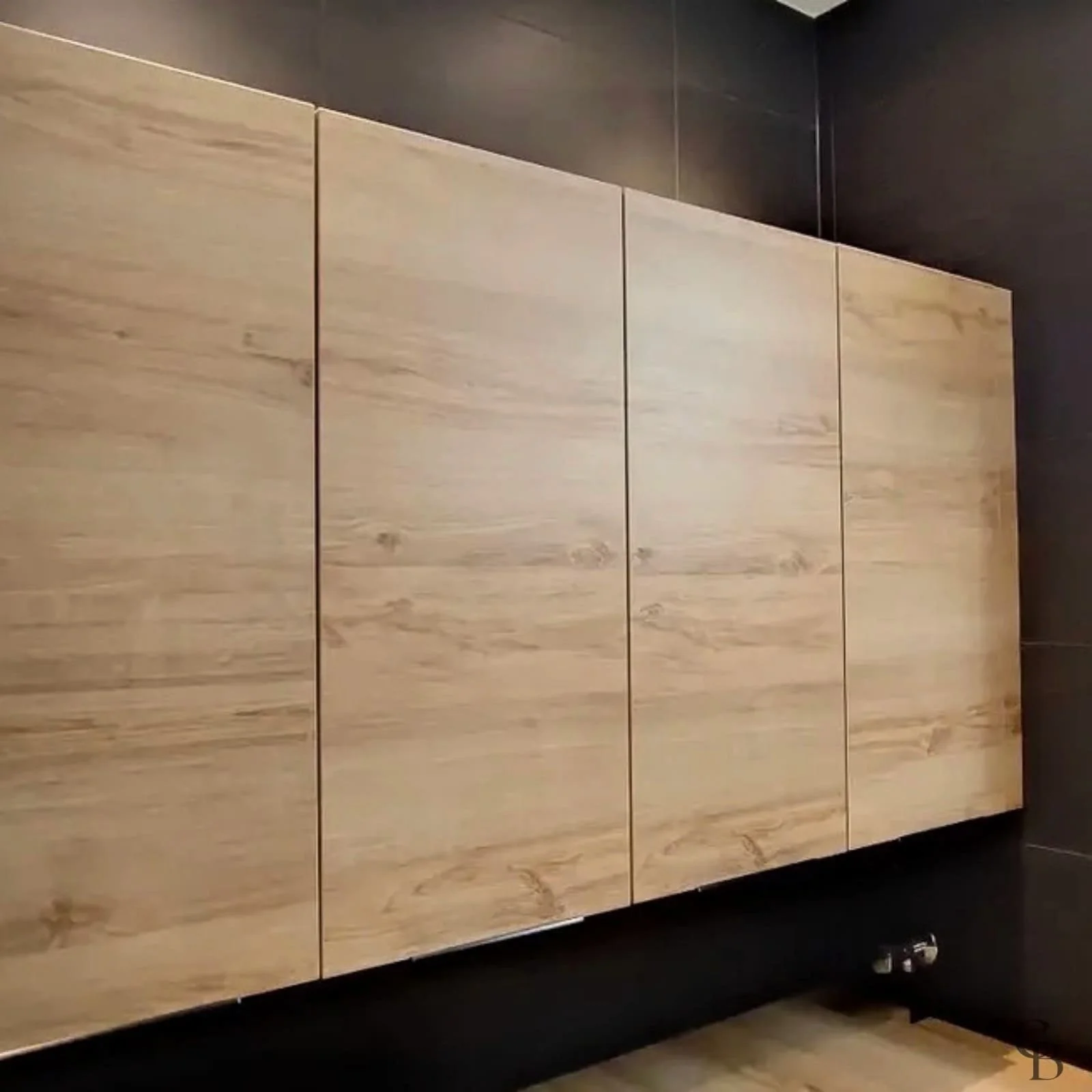 Texte ALT Meuble de salle de bains suspendu sur mesure réalisé à Thônex, avec façades effet bois, rangements intégrés et design contemporain parfaitement adapté à l'espace.