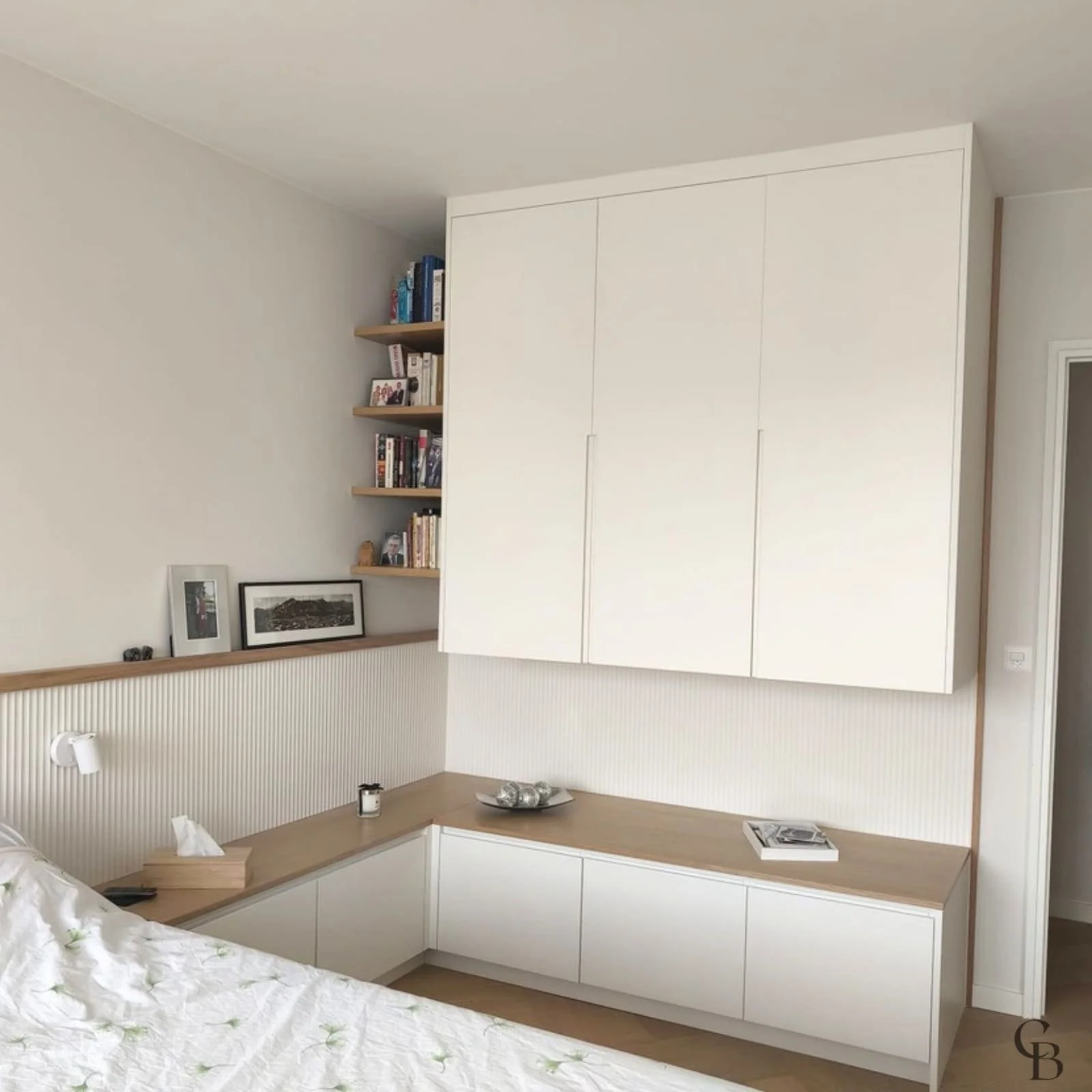 Concept & Bois a imaginé cet aménagement de chambre parentale sur mesure afin de créer un espace à la fois élégant et fonctionnel. Les armoires suspendues, le mobilier intégré, l'habillage mural et les étagères en chêne optimisent le rangement tout e