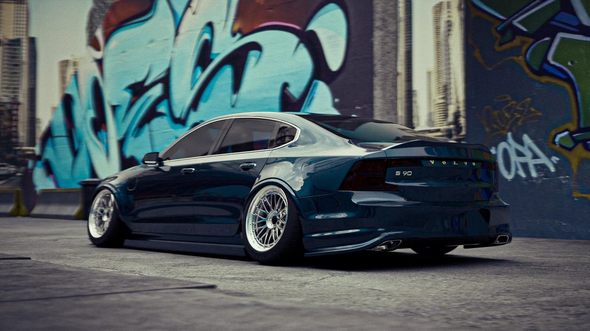 Une voiture noir brillant modèle Volvo S90 stationnée sur une rue urbaine avec un mur couvert de graffiti bleus en arrière-plan.