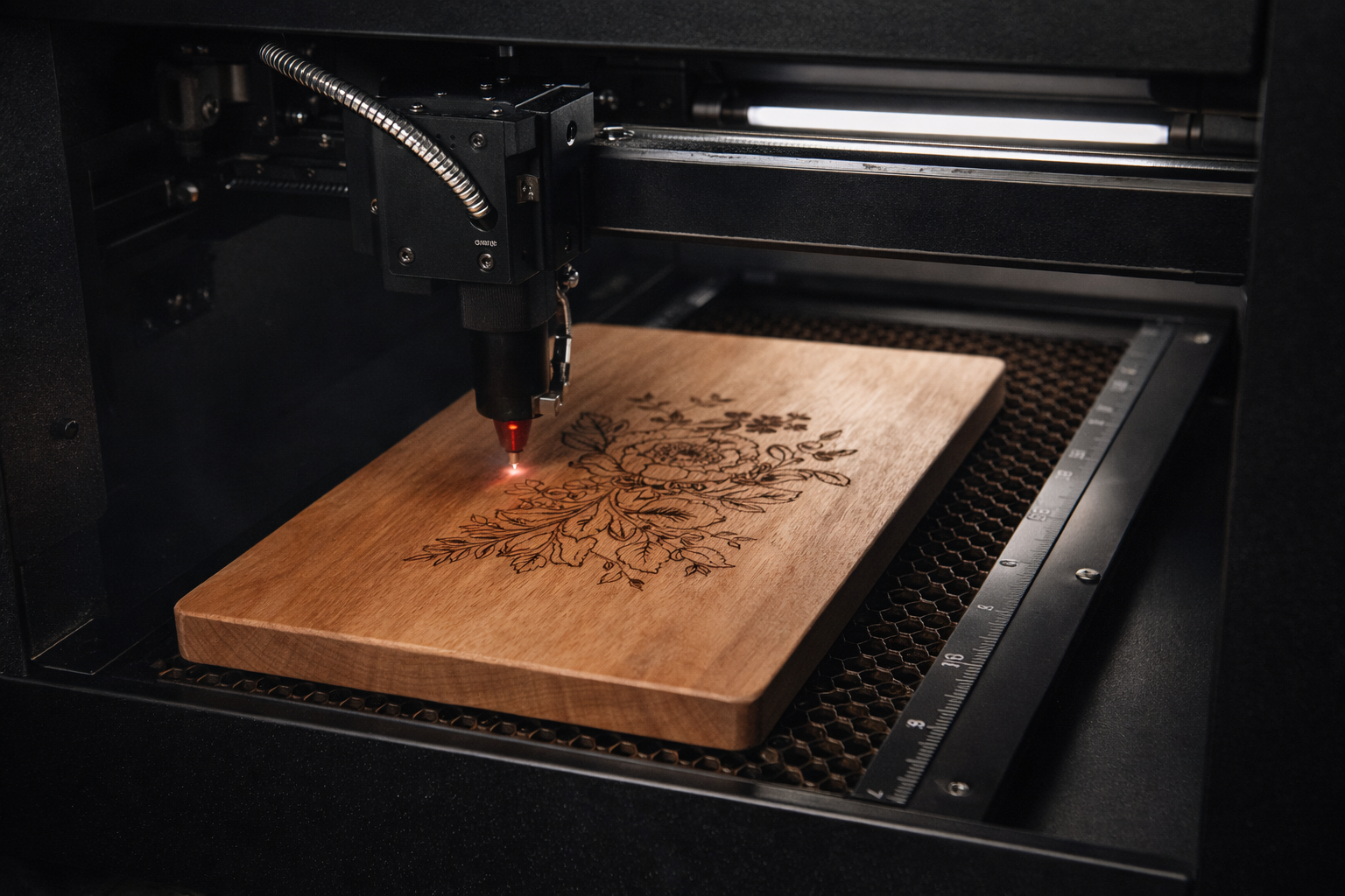 A CO₂ laser engraves a floral design into hardwood, showing the precision and craftsmanship behind custom laser work.