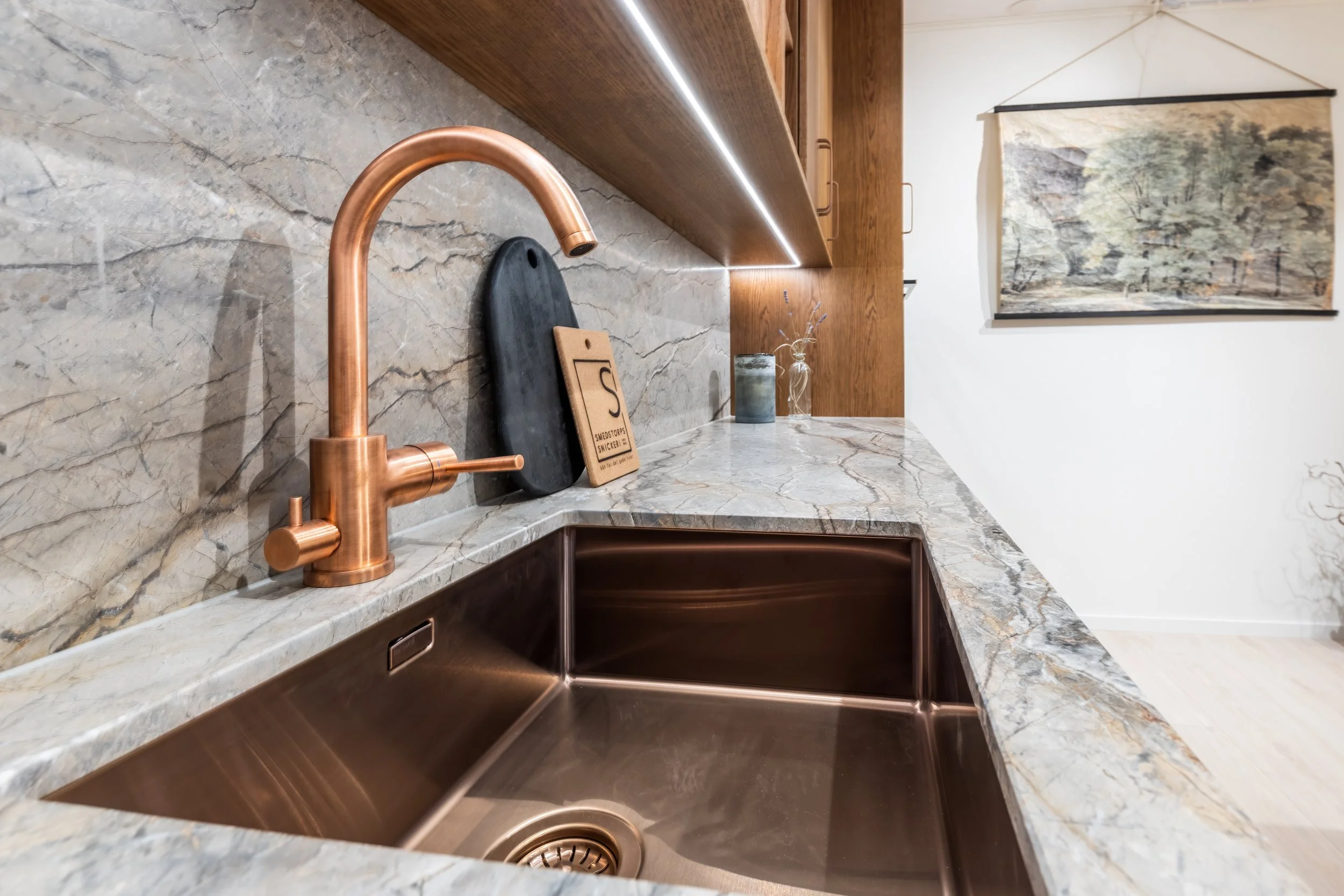 Detaljbild av kopparkran och stenbänkskiva i platsbyggt kök från Smedstorps Snickeri.