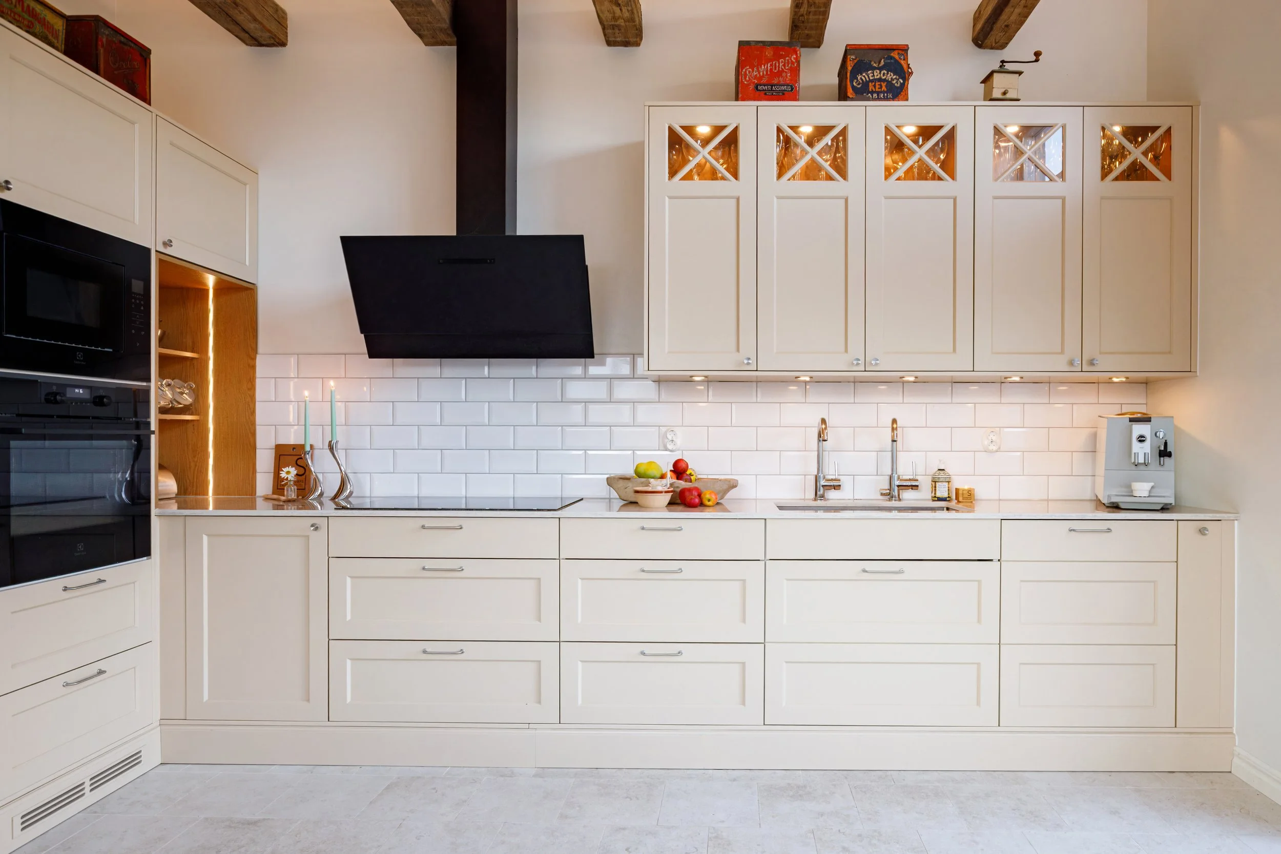 Klassiskt vitt kök från Smedstorps Snickeri med kaklad vägg och platsbyggda skåp.