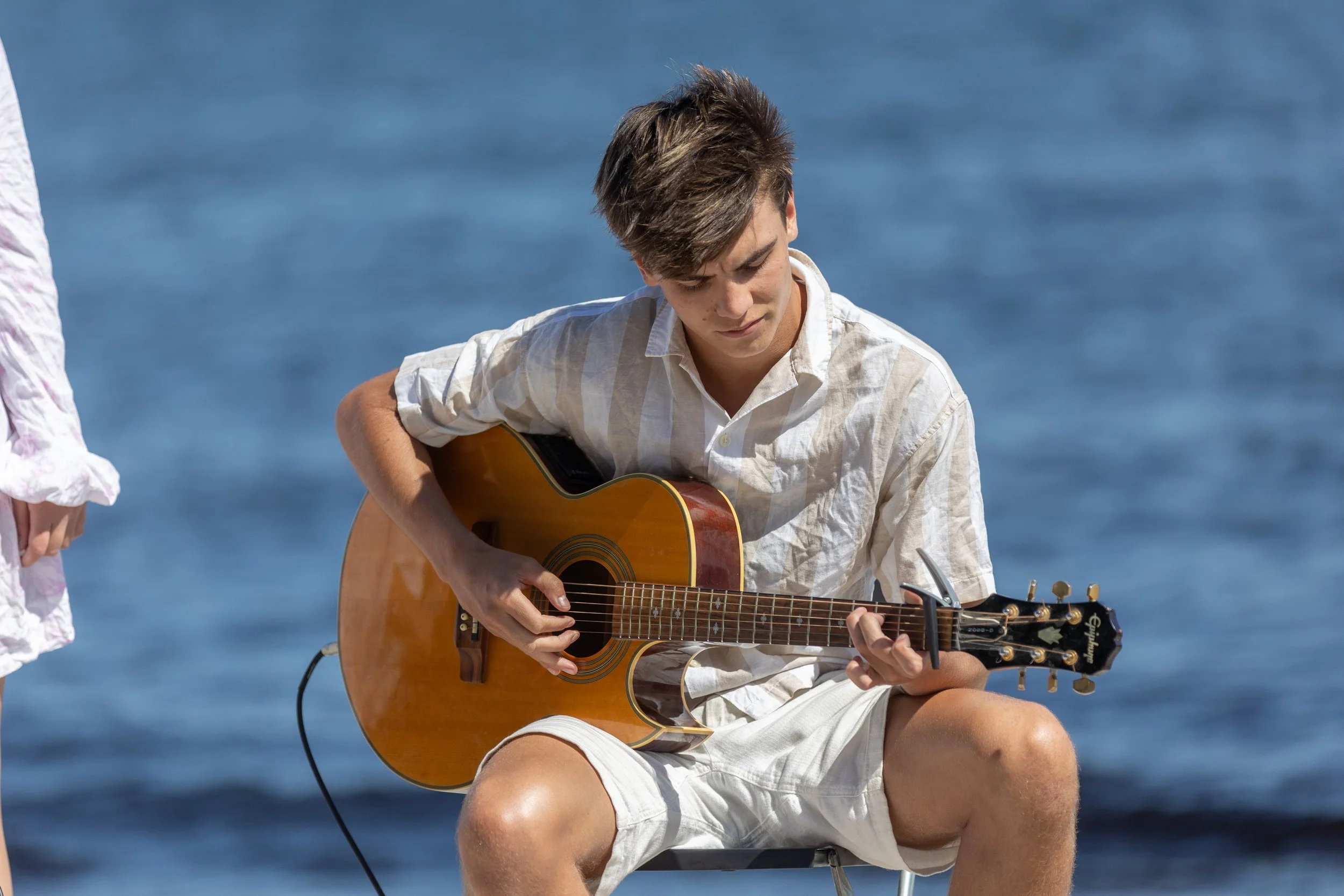 Gitarrspelande kille på stranden på bröllop, Fotograf Jeanette Lindeskog.jpg
