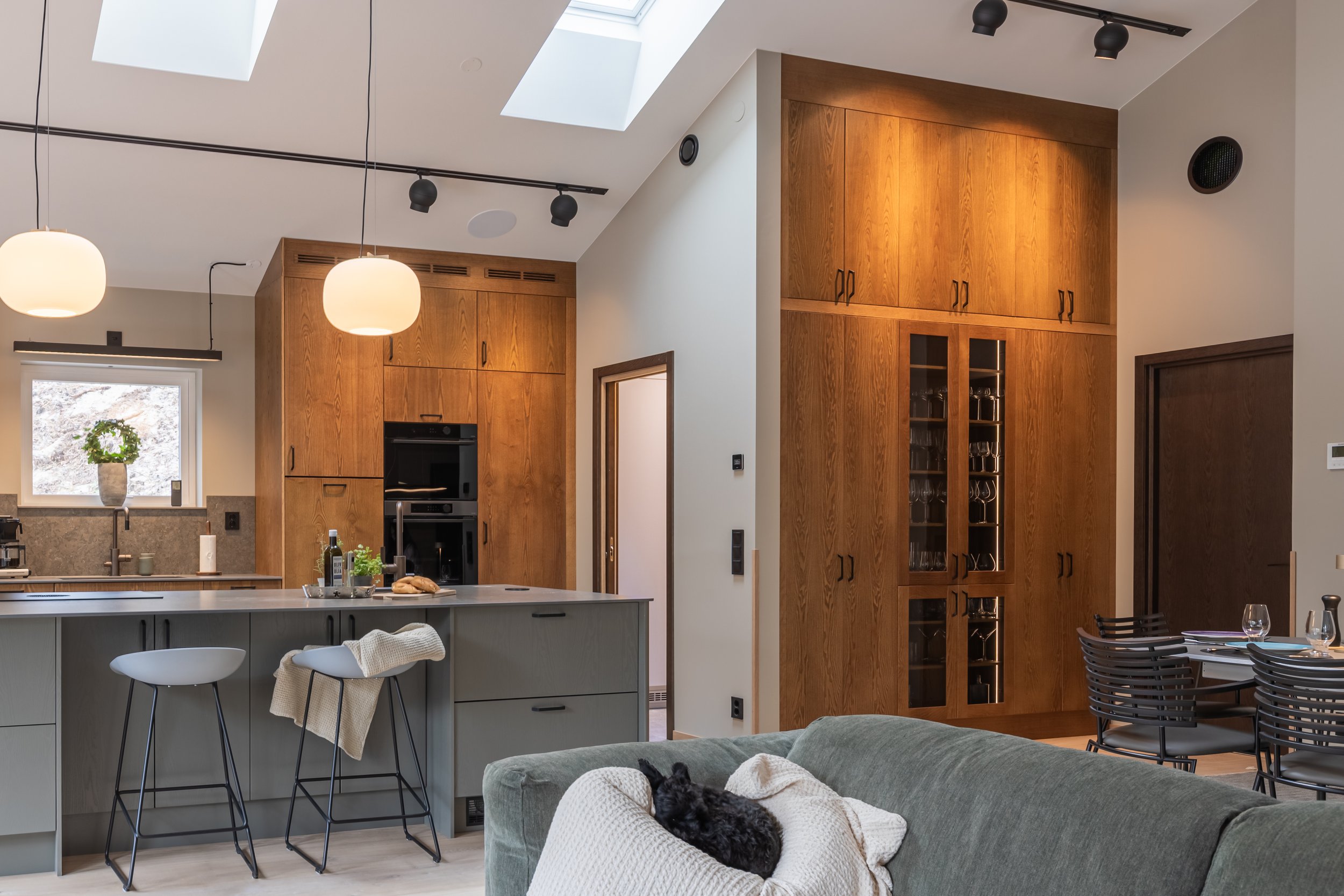 Platsbyggt kök i valnöt med köksö från Smedstorps Snickeri, fotograferat i ett modernt hem med högt i tak.
