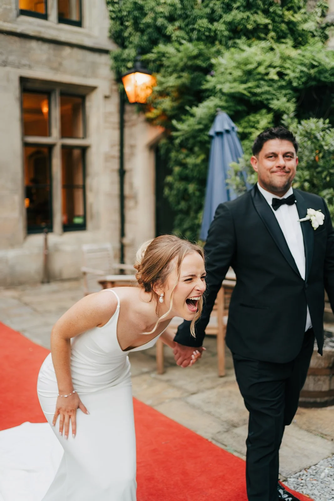 Bride laughing on red carpet during the wedding evening reception