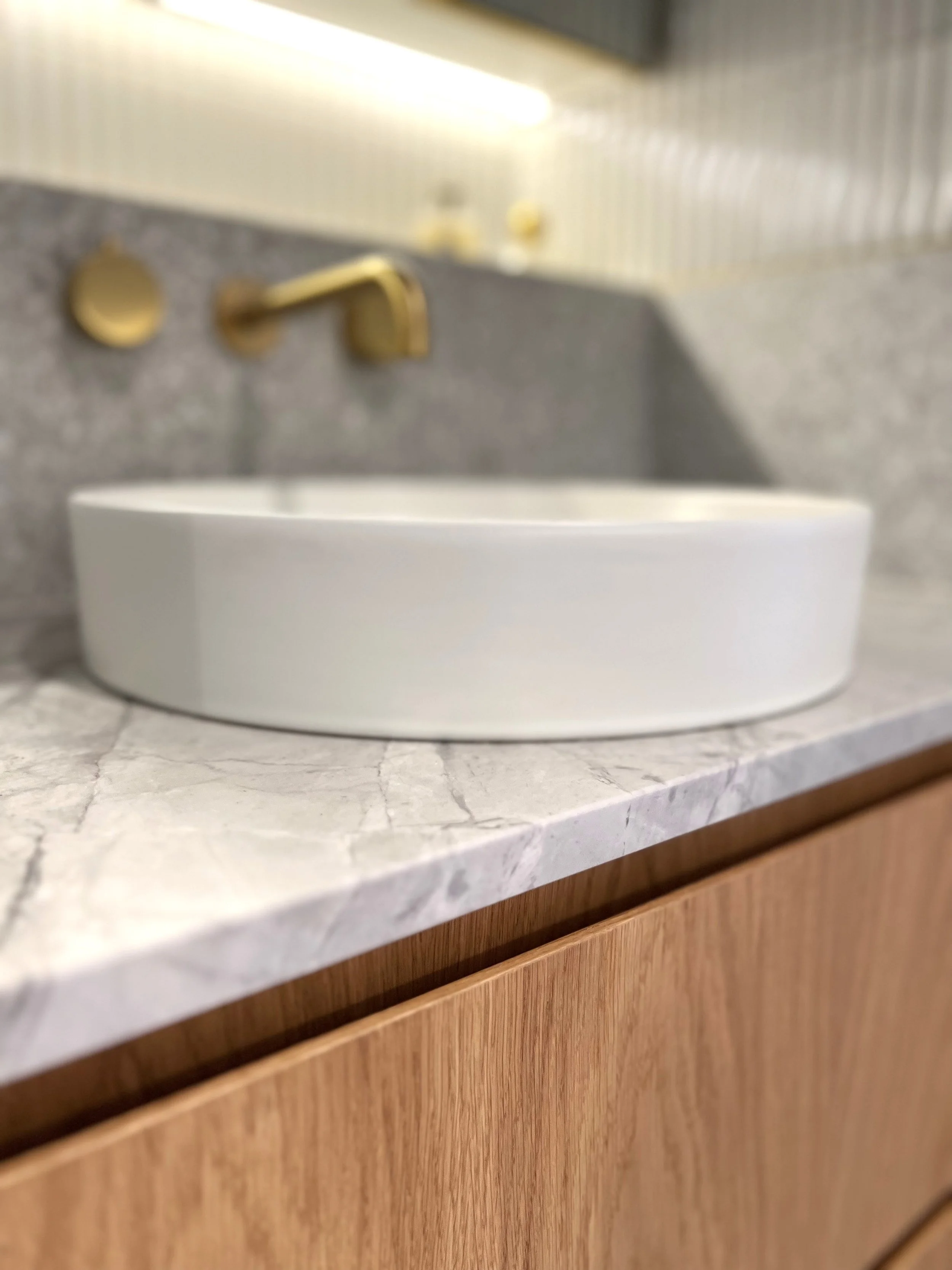 Stone and timber and brass bathroom