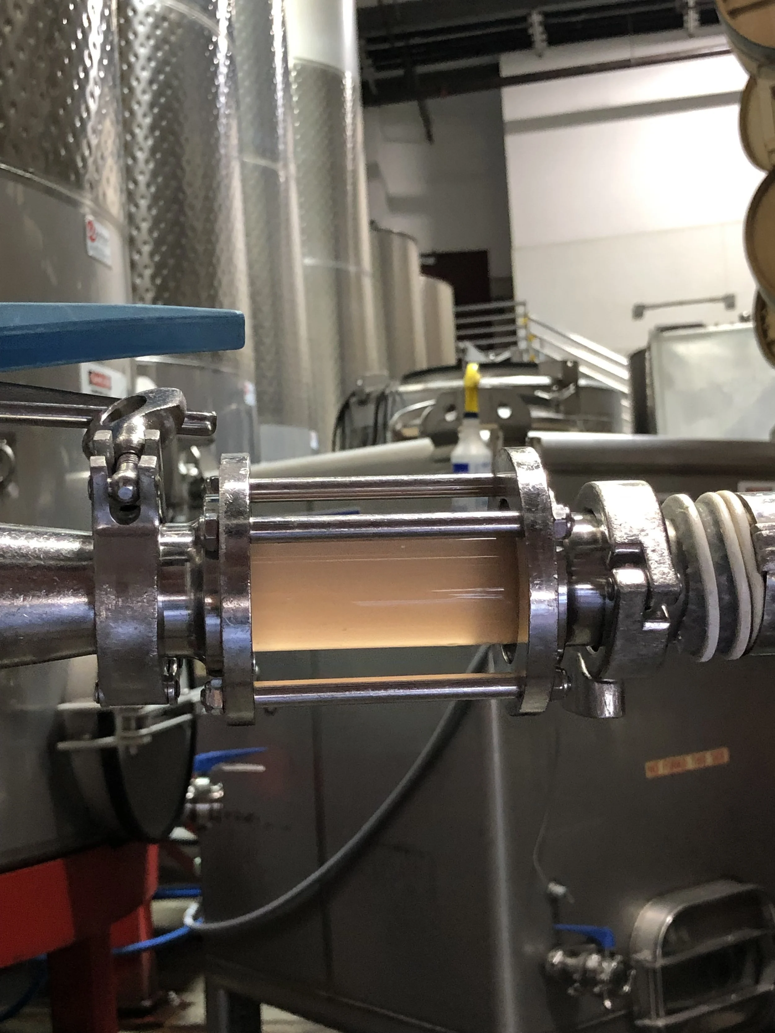 Close-up of stainless steel machinery with metal rollers in an industrial setting.