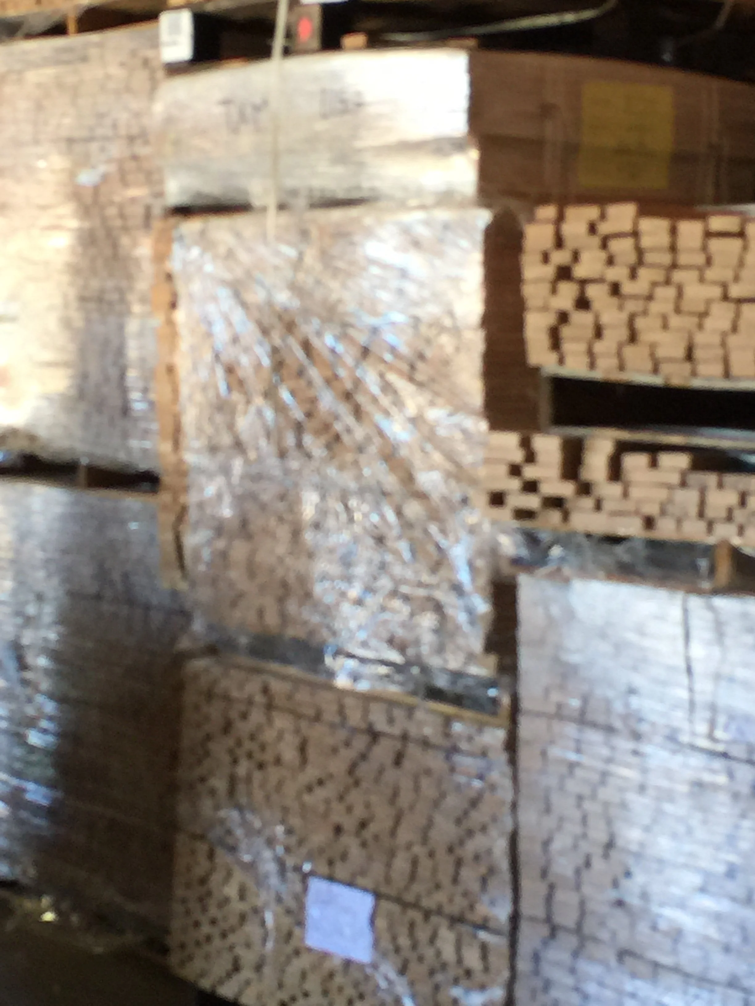 A close-up photo of several stacked bricks, with some part of construction or a brick wall visible in the background.