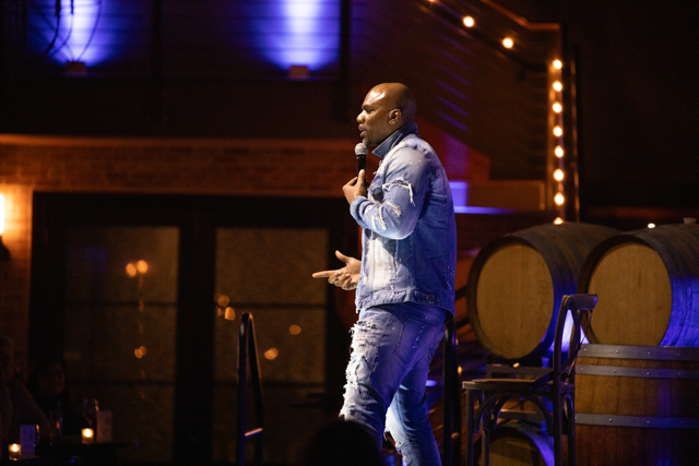 Comedian performing on stage with microphone