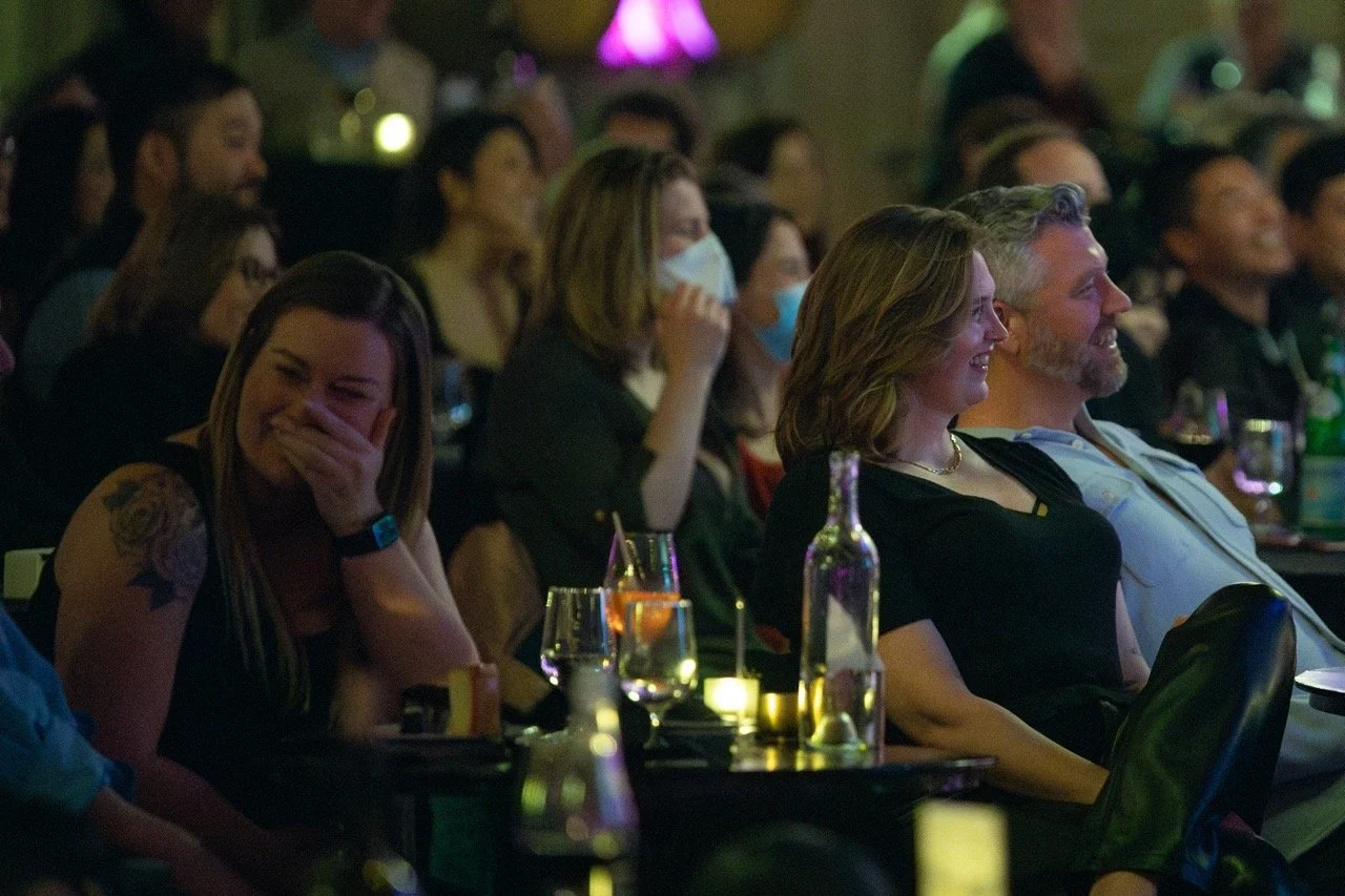 Audience at a comedy show laughing and enjoying performance