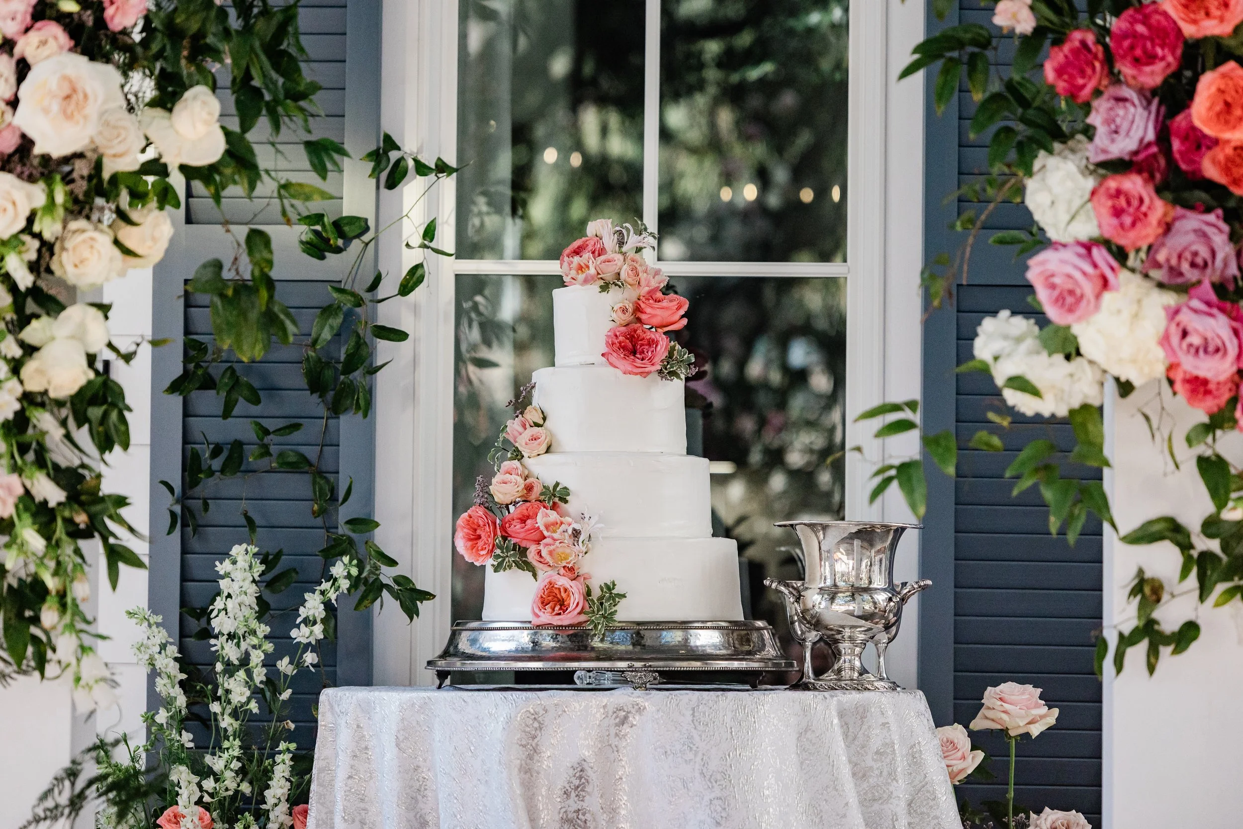 wedding cake with pink cascading flowers outside at old historic venue