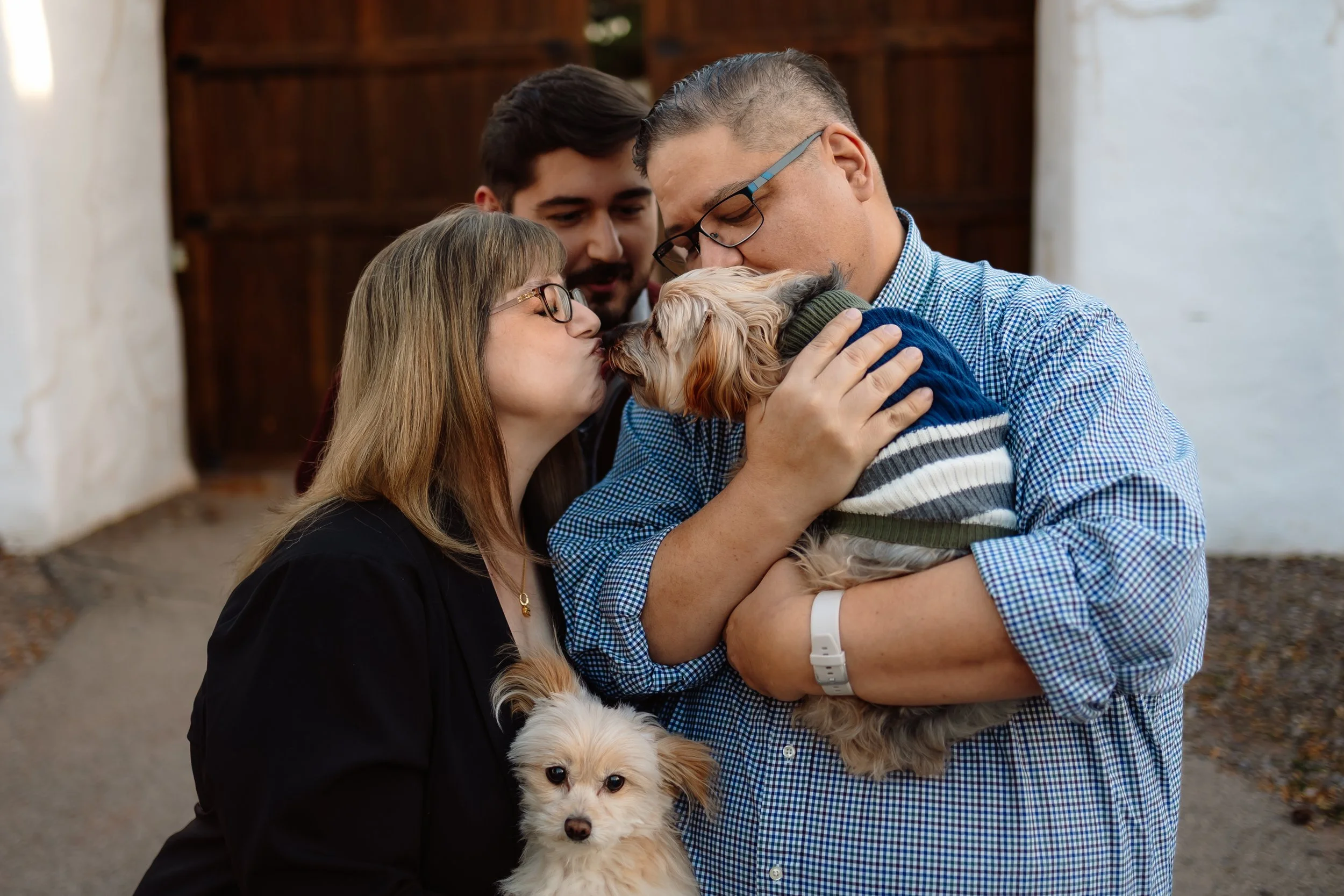 family with their dogs giving them kisses