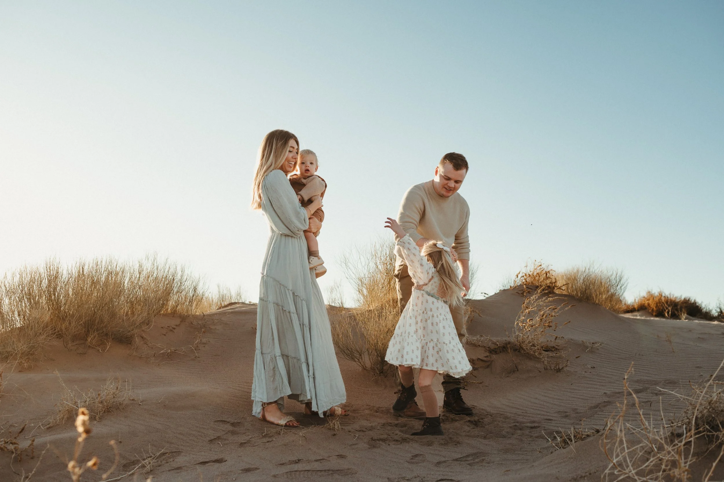 a dad twirls his young daughter around while mom and baby brother watch with smiles, el paso tx desert images