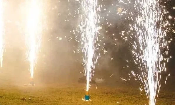 Feux d'artifice au sol proposés par Beirut Zaffé explosant dans le ciel nocturne, illuminant le lieu de réception du mariage.