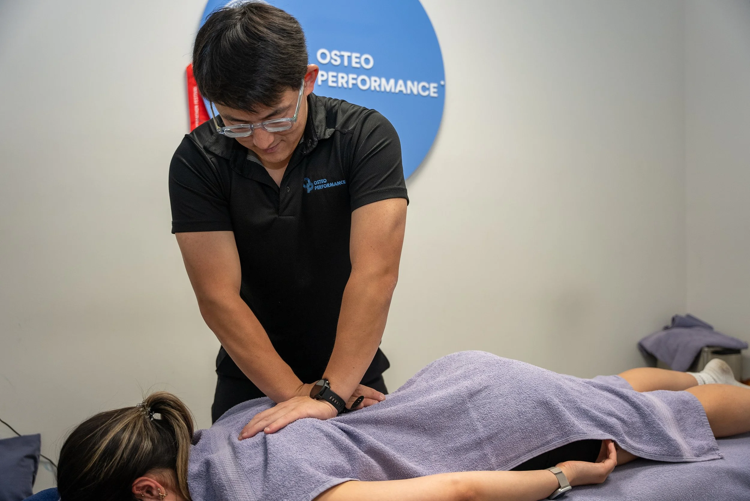 A person receiving chiropractic adjustment from a practitioner in a therapy room.