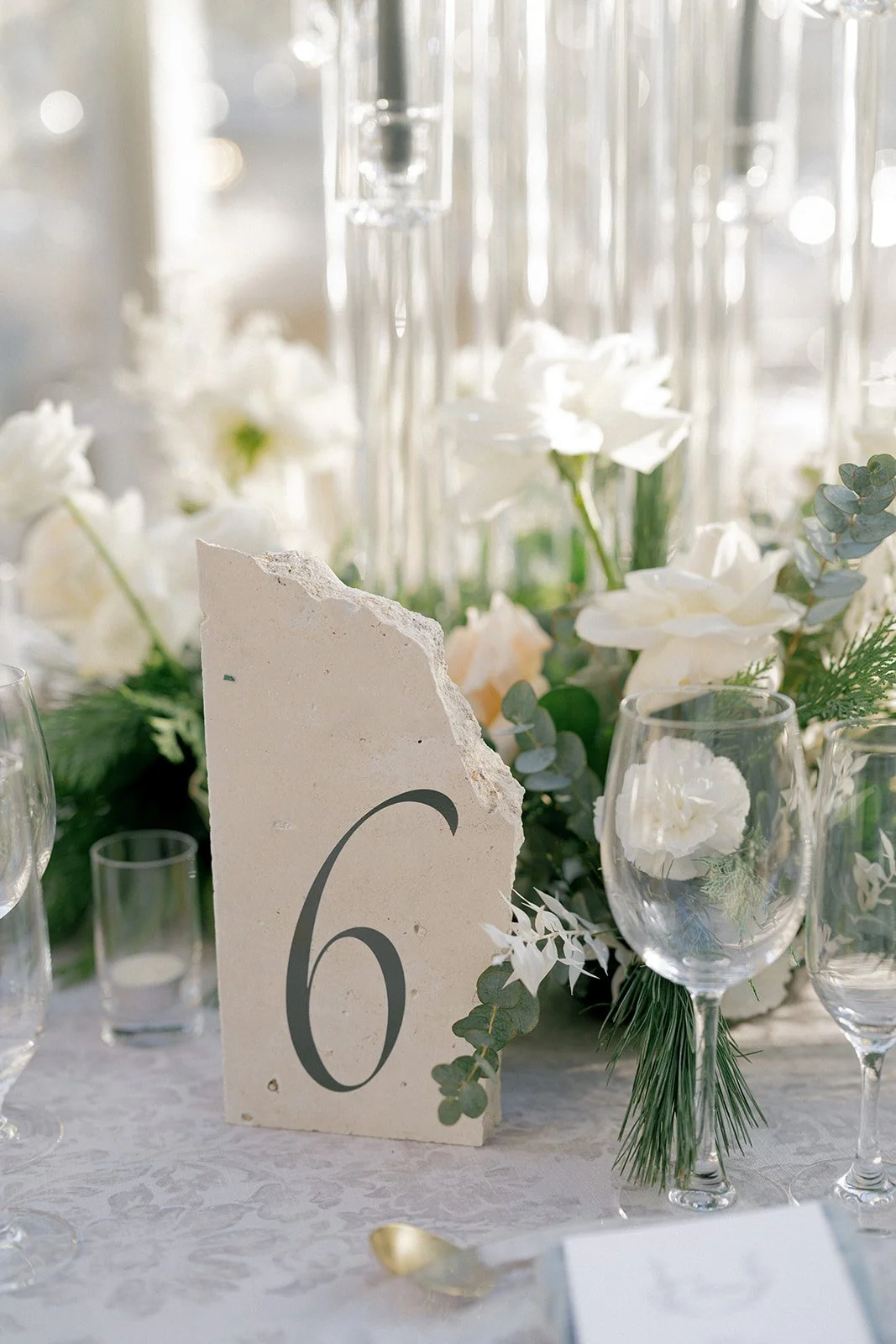  Bride and groom during toast at winter wedding reception at St. Regis Deer Valley, with lush white and gray-blue florals, crystal chandeliers, and acrylic candelabras. 