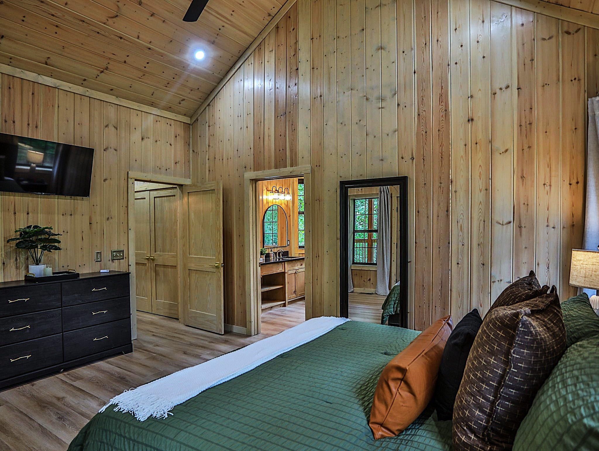 The primary bedroom suite with dresser and smart tv.