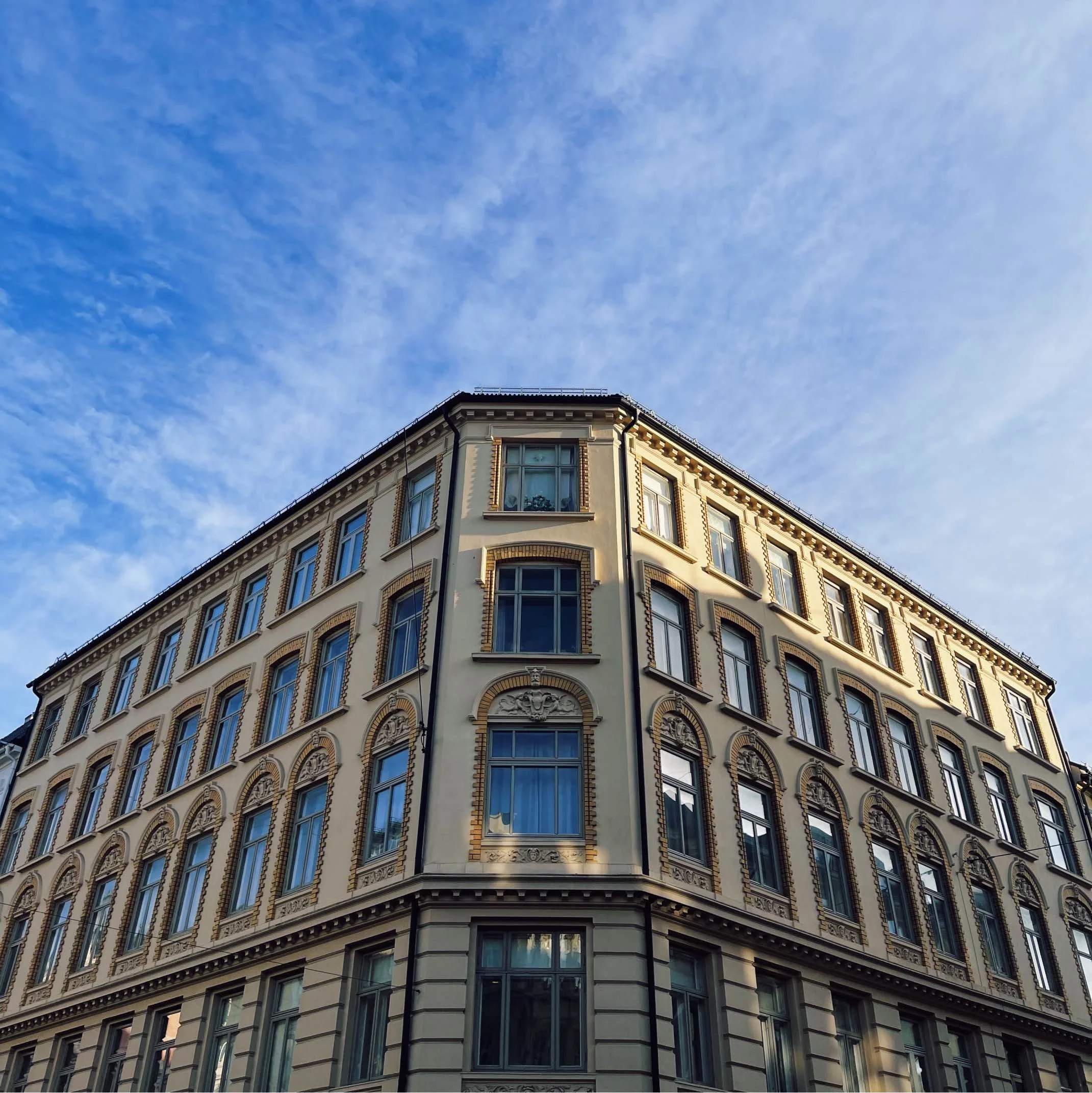 Bilde av tradisjonell fasade i gullfarge i Oslo, med en klar blå himmel synlig. Fasaden befinner seg på Majorstuen.