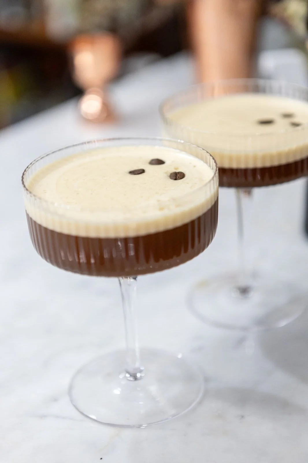 Fresh espresso martinis topped with crema and coffee beans—cocktail perfection ready to be sipped.