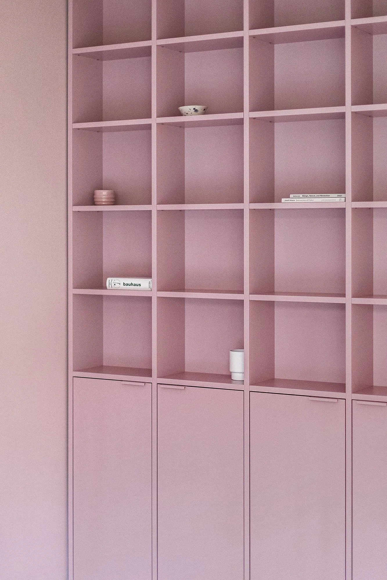 A custom built-in bookshelf in Farrow & Ball Cinder Rose, Mitte Berlin