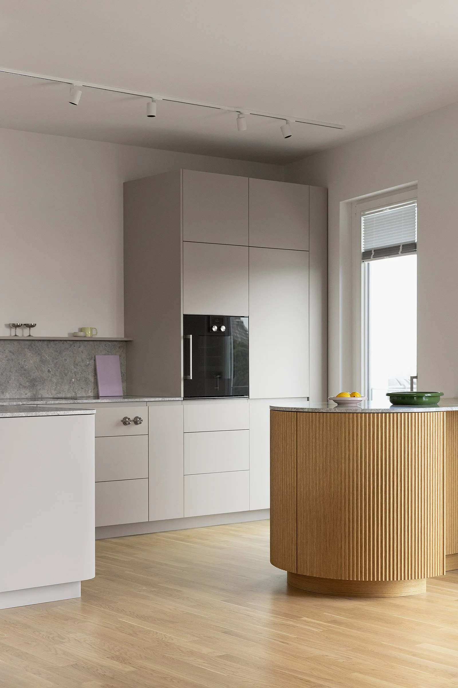 A custom cashmere grey kitchen with warm grey marble worktop and oak-clad island, Spandau Berlin